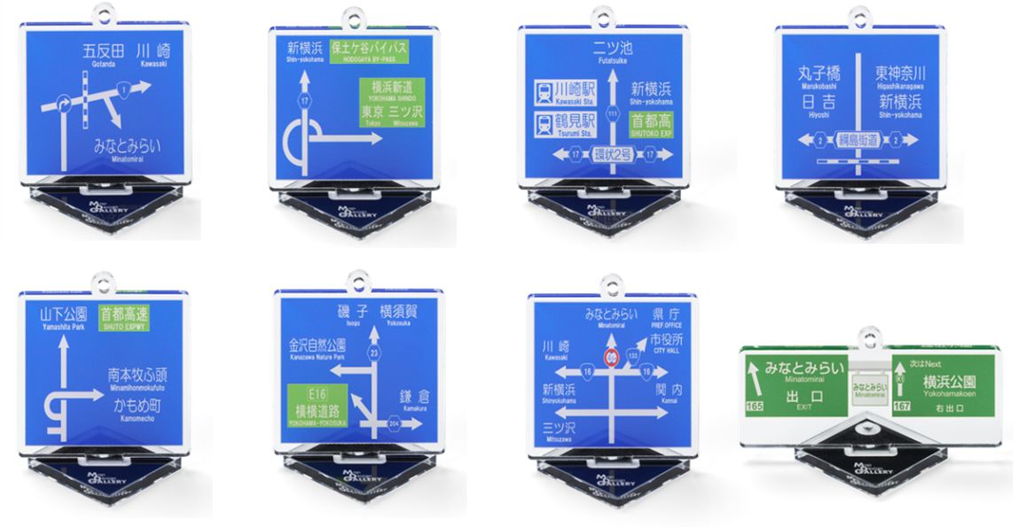 SNSでたびたび話題となっている方面案内看板をモチーフにしたアクキーは、全8種ランダム・1個500円。左上から横浜市西区、保土ヶ谷区、鶴見区、港北区、中区、金沢区、中区、首都高速神奈川1号横羽線みなとみらい出口（特別仕様デザイン）