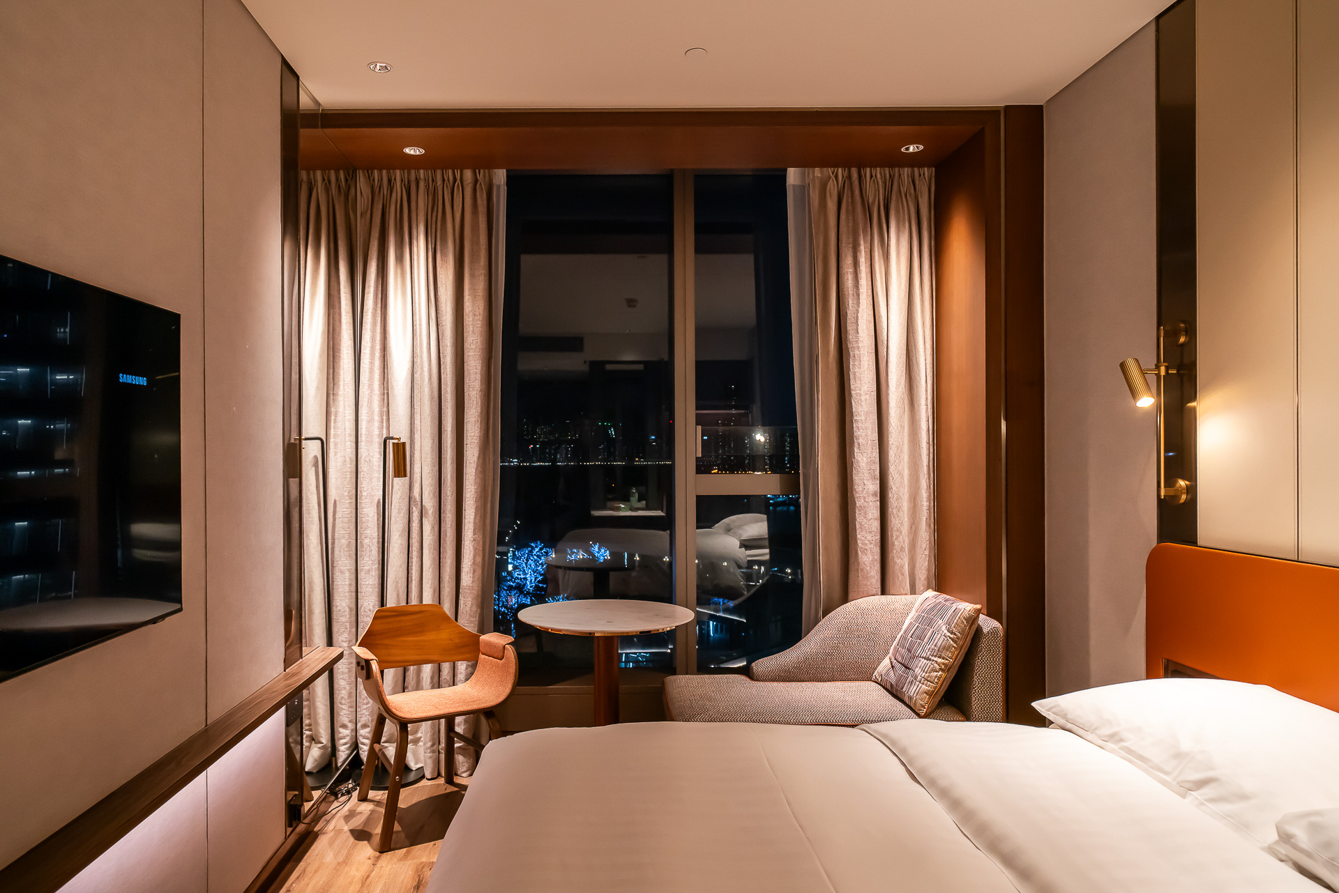 窓際に丸テーブルにイスと小さめのソファ