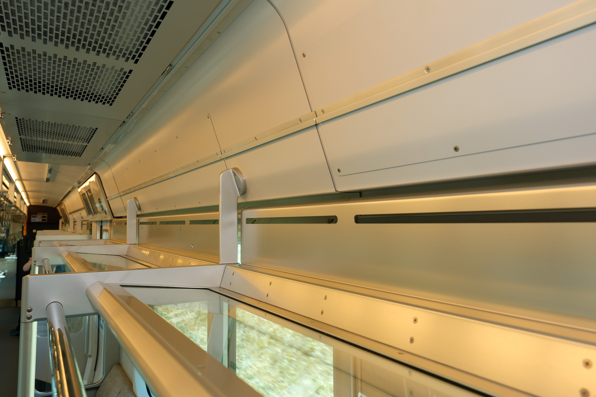 荷棚はガラス製で、奥の方に落下防止用の板が設けられている。側窓はUVカット機能を持つ熱線吸収合わせガラスを使用しているため、ロールカーテンはない