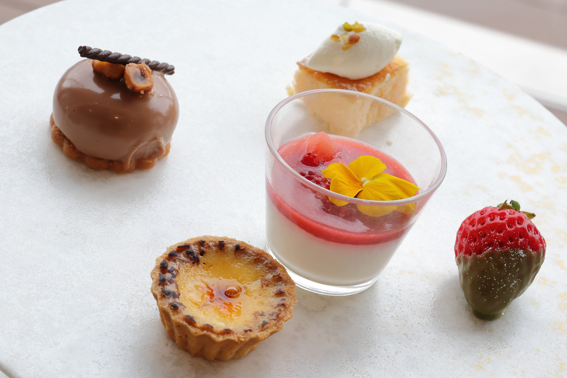 ティースタンド上段（ヘーゼルナッツチョコレートケーキ、エッグタルト、苺の杏仁豆腐、苺の抹茶チョコ付け、スフレチーズケーキ）