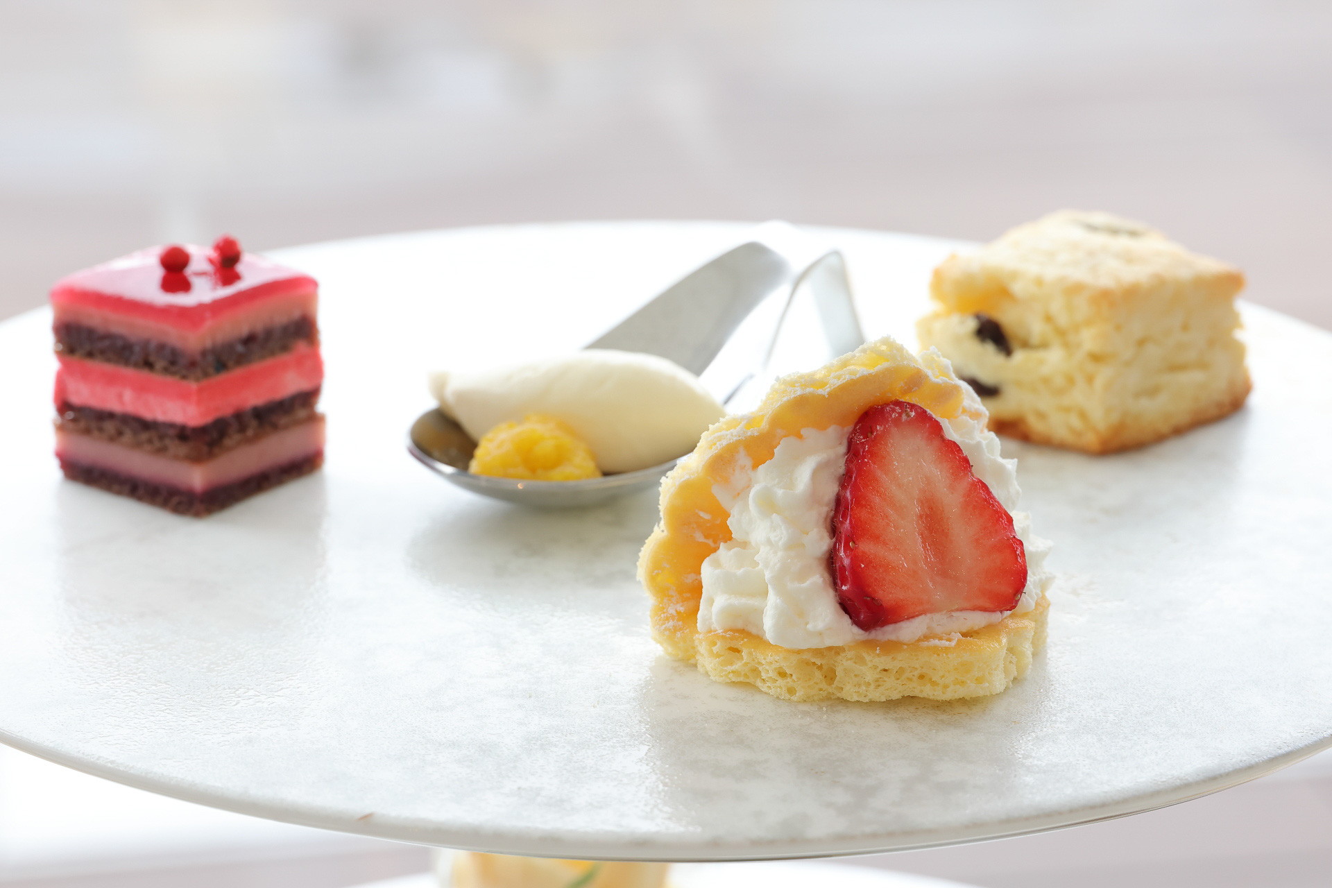 ティースタンド中段（ラズベリーとピンクペッパーのオペラ、クロテッドクリームとオレンジコンフィ、苺のショートケーキ、レーズンスコーン）