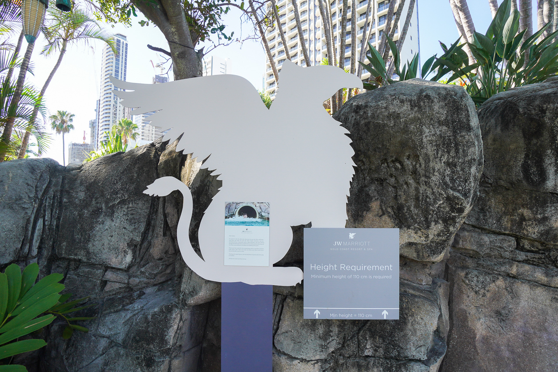 「JWマリオット」ロゴのグリフィン看板で、子供用スライダーの身長制限