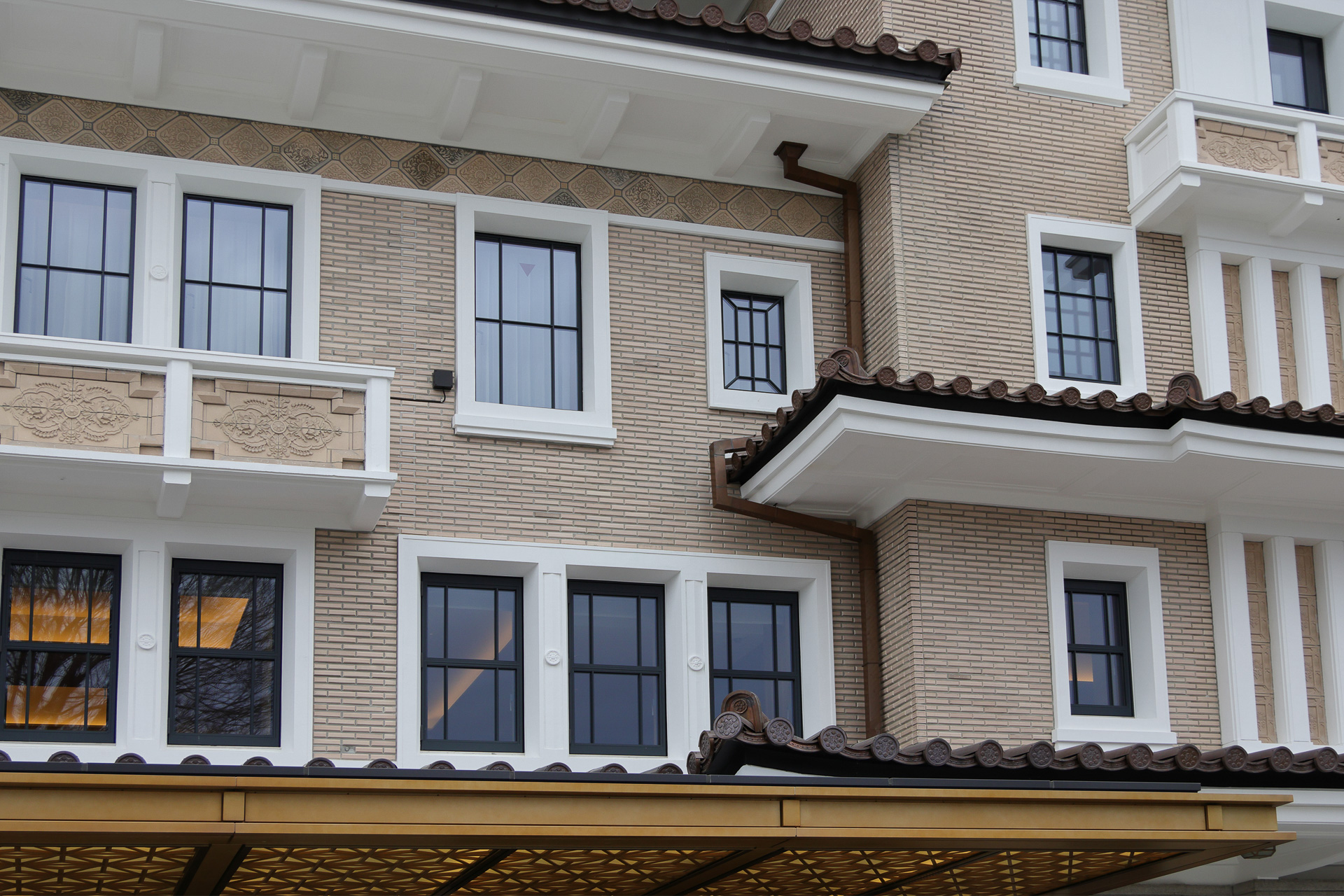 生け捕りタイルと復刻タイルが共存する南側の壁面。水平と垂直の複雑な組み合わせは、どことなく旧帝国ホテル本館（ライト館）とのつながりを感じさせる