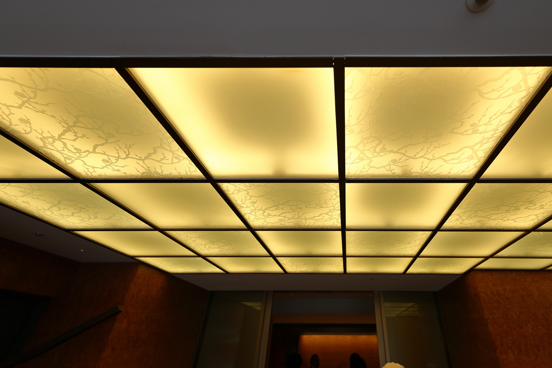 風除室天井のエッチングガラスは弥栄会館時代のものをそのまま使用。梅の枝がデザインされている