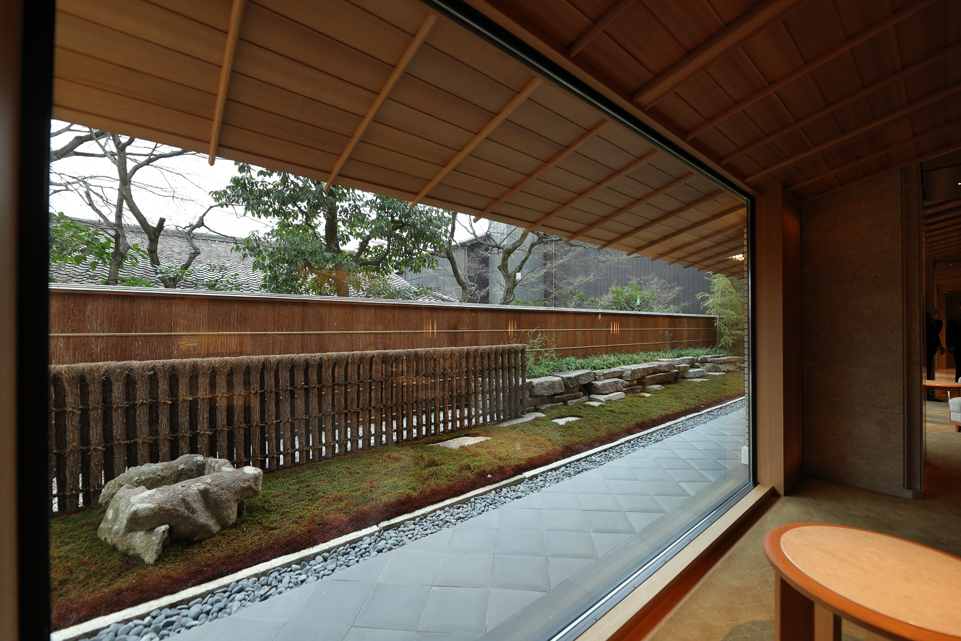 開放感のある大きな窓と坪庭。天井を傾斜させて庇と続くように見せている