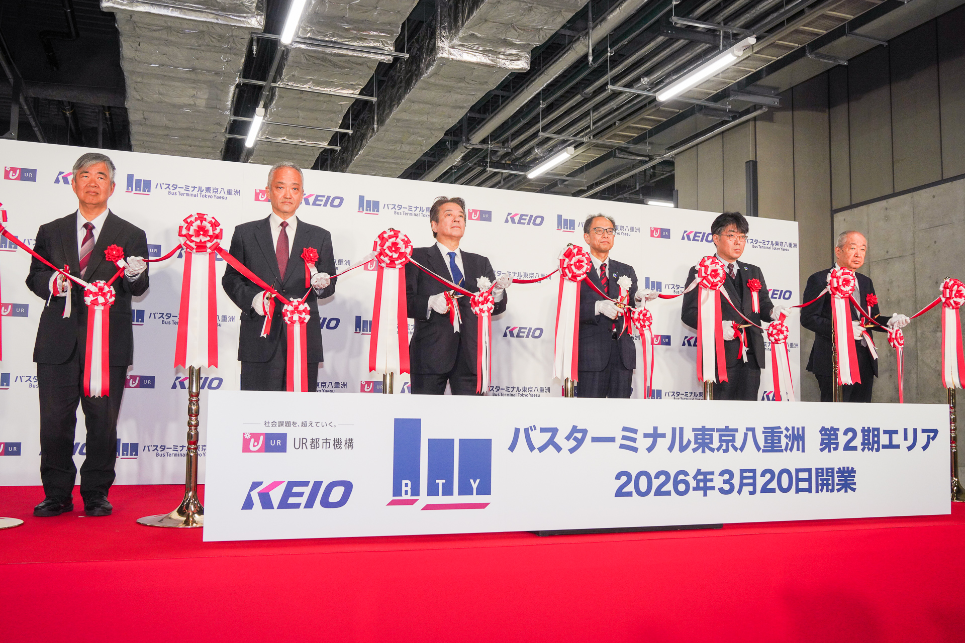 テープカット。写真左から、東京大学大学院 新領域創成科学研究科 特任教授 中村文彦氏、中央区副区長 田中智彦氏、京王電鉄バス株式会社 代表取締役社長 宮坂周治氏、独立行政法人都市再生機構 東日本都市再生本部長 西野健介氏、国土交通省 都市局 街路交通施設課 課長 筒井祐治氏、八重洲一丁目東B地区市街地再開発組合理事長 加藤一男氏