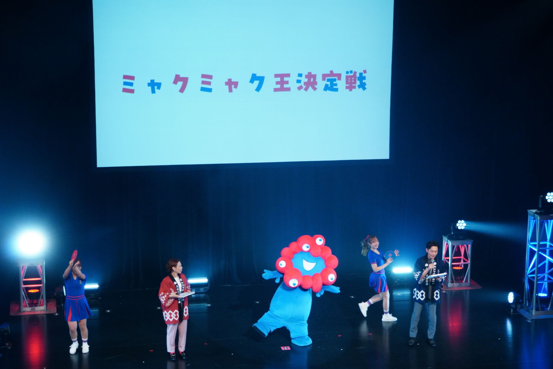 全問正解できたのはたった1人！　サイン入りの黒ミャクミャクブロマイドが贈られ喜ぶ姿に、観客も思わず「かわいい～」ともらす