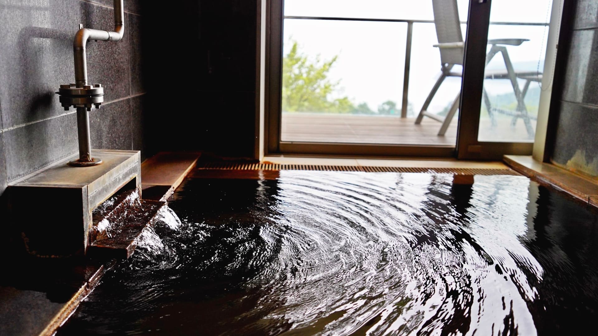 全客室に専用のバルコニーと100％源泉かけ流し半露天風呂が備わる