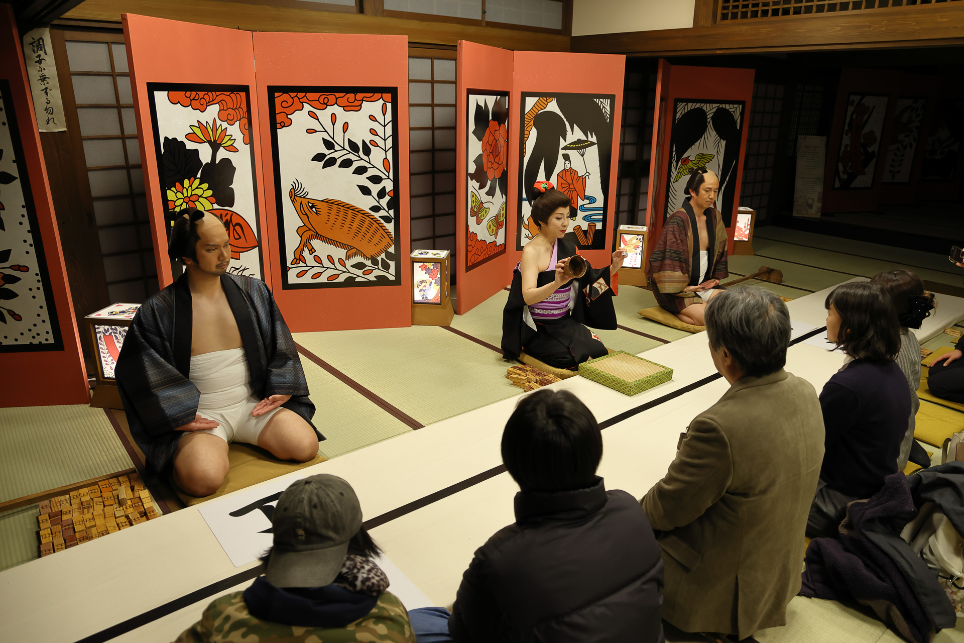 弐之間 夜の演目「半丁博打」。壺振りと合力に向かい合わせに座りゲームに参加する