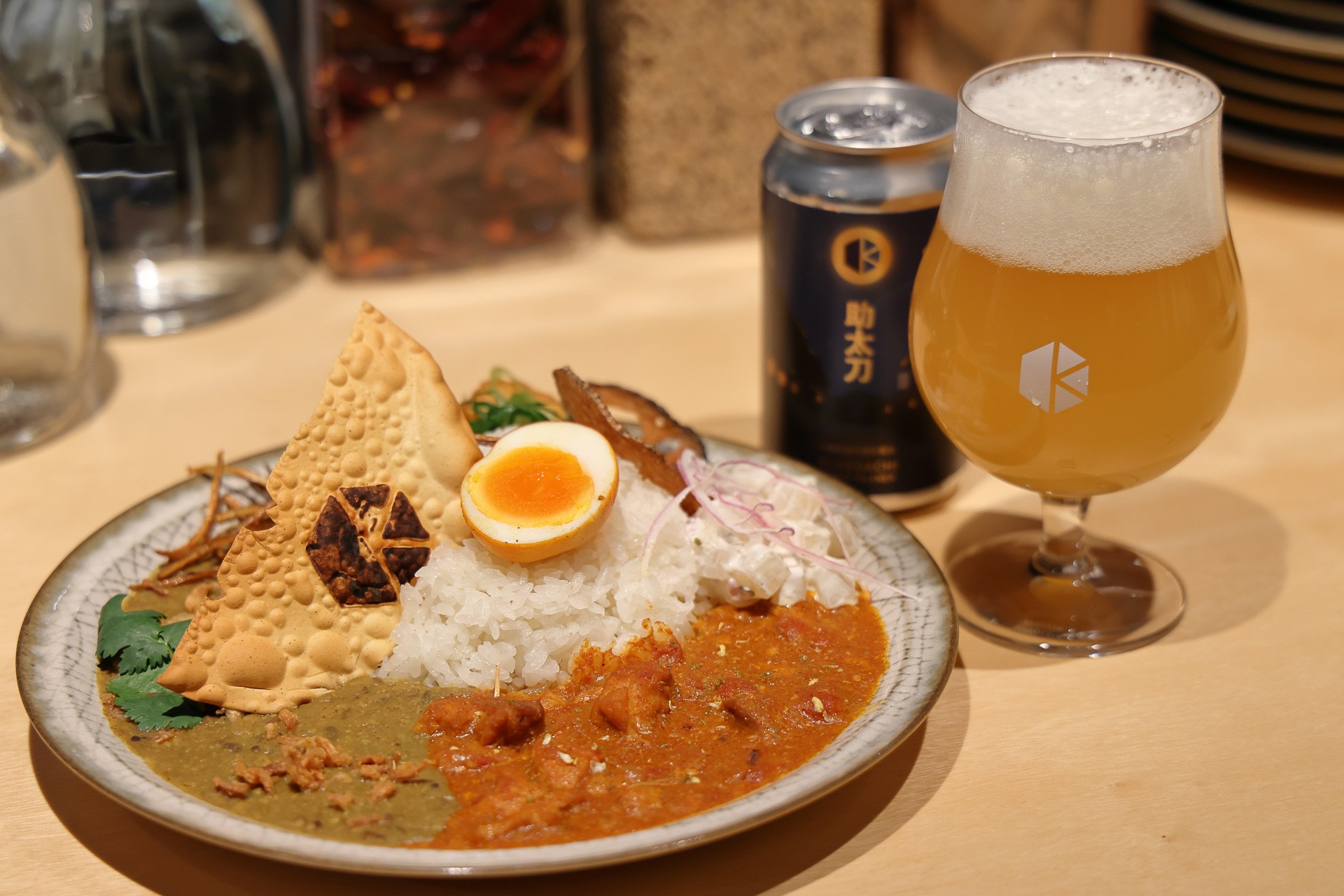 「味隠」は、鼻を抜ける爽やかな辛さが特徴のスパイスカレーと地元京都のクラフトビールを提供する。写真は「あいがけスパイスカレー」と「映画村限定ビール-助太刀-」