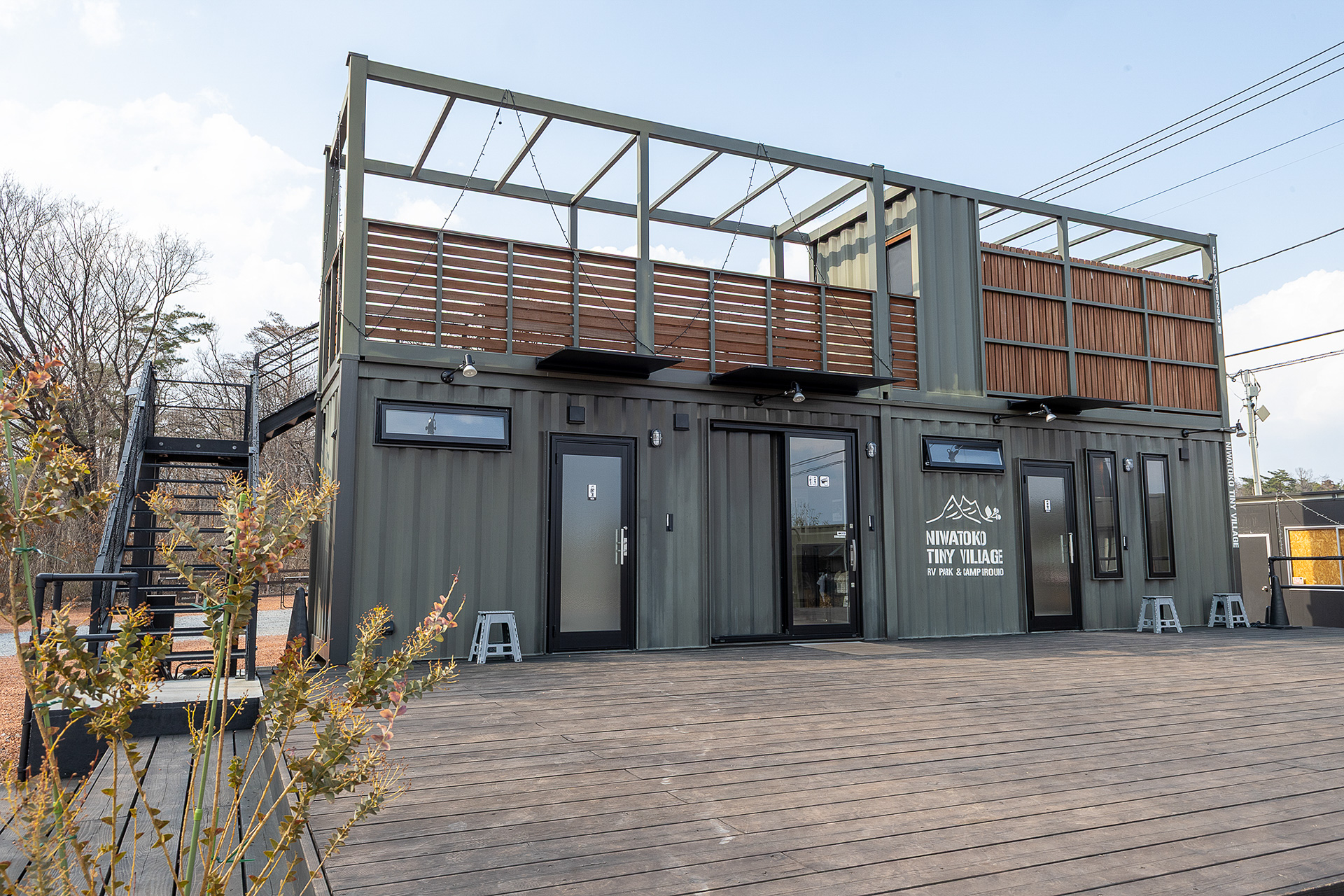 ニワトコRVパークのシンボル的な建物であるサニタリー棟。芝生に面した正面側は広々としたウッドデッキになっている。将来的には、ここでアコースティックライブなどイベントをやりたいとのこと