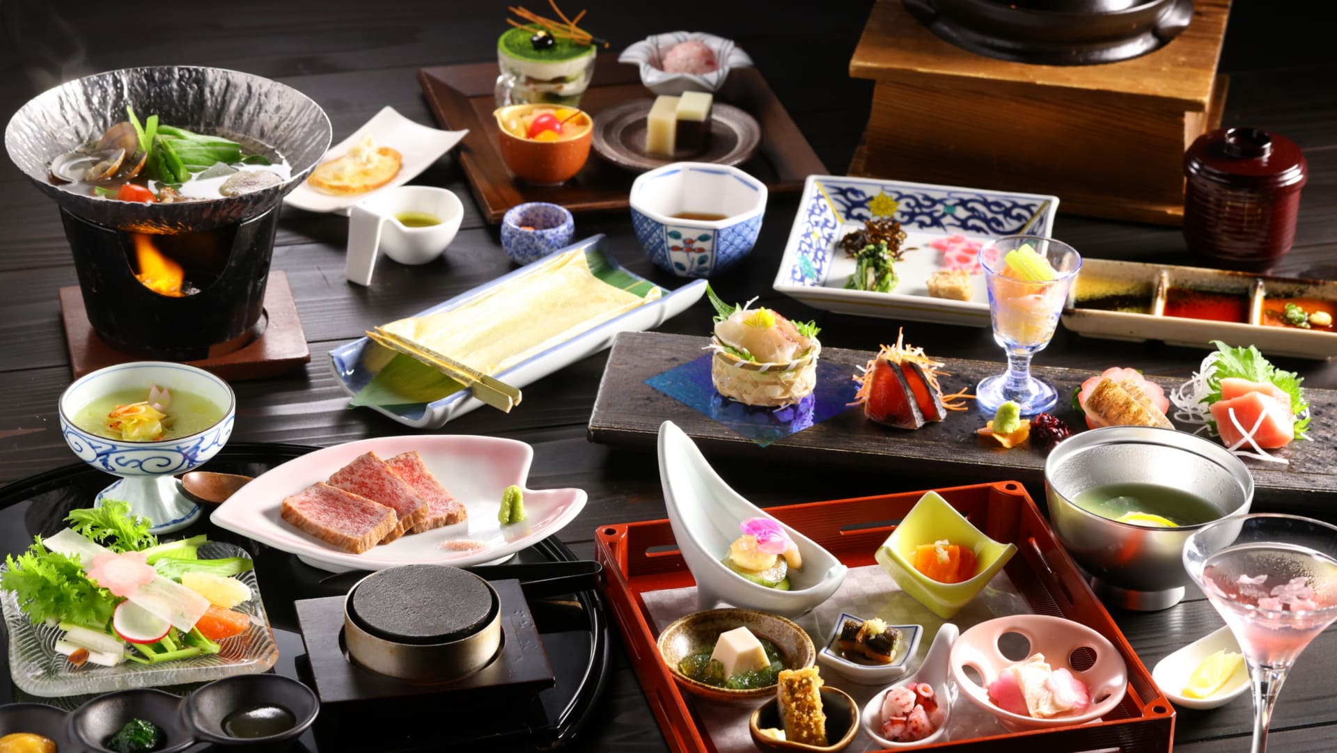 夕食会席コース（写真は春の例）。自家製引き上げ湯葉をはじめ、食前酒の“文豪カクテル”、地場産カツオや桜鯛のお造り、湯河原の歴史・自然にちなんだ前菜、メインの和牛サーロインステーキなど