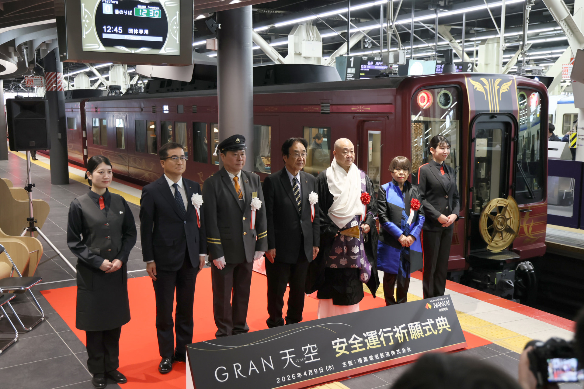 式典の結びに、列席者によるフォトセッションが行なわれた。両脇はアテンダントで、その内側には左からNANKAIの岡嶋社長、南海電鉄の梶谷社長、遠北会長、総本山金剛峯寺の今川執行長、コシノ ジュンコ氏