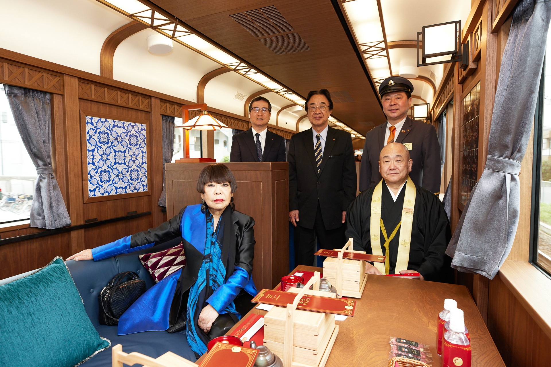 安全運行祈願式典の出席者による車内でのフォトセッション。前列にコシノ ジュンコ氏と高野山真言宗 宗務総長の今川泰伸氏。後列左から株式会社NANKAI 代表取締役社長兼COO 岡嶋信行氏、代表取締役会長兼CEO 遠北光彦氏、南海電気鉄道株式会社 取締役社長 梶谷知志氏（写真提供：南海電鉄）