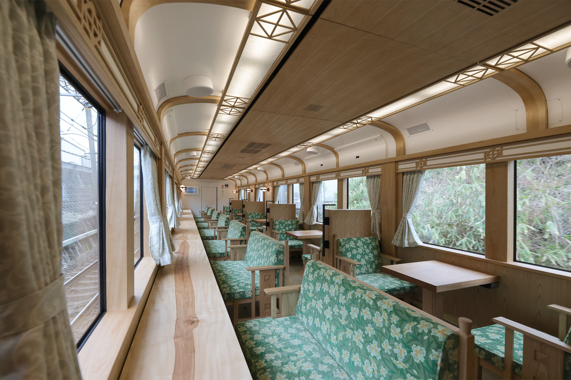 木材をふんだんに使った和のしつらえ。シート地は緑で、シャクナゲがあしらわれているようだ