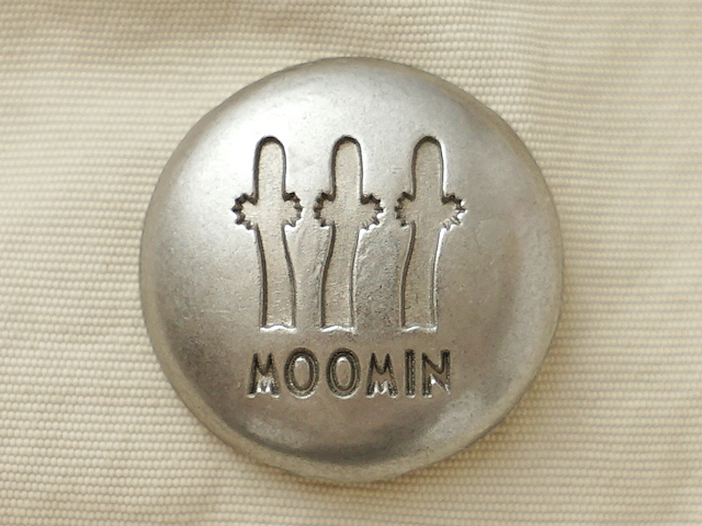 トップにはニョロニョロを刻印したボタン。荷物の飛び出しを防止する