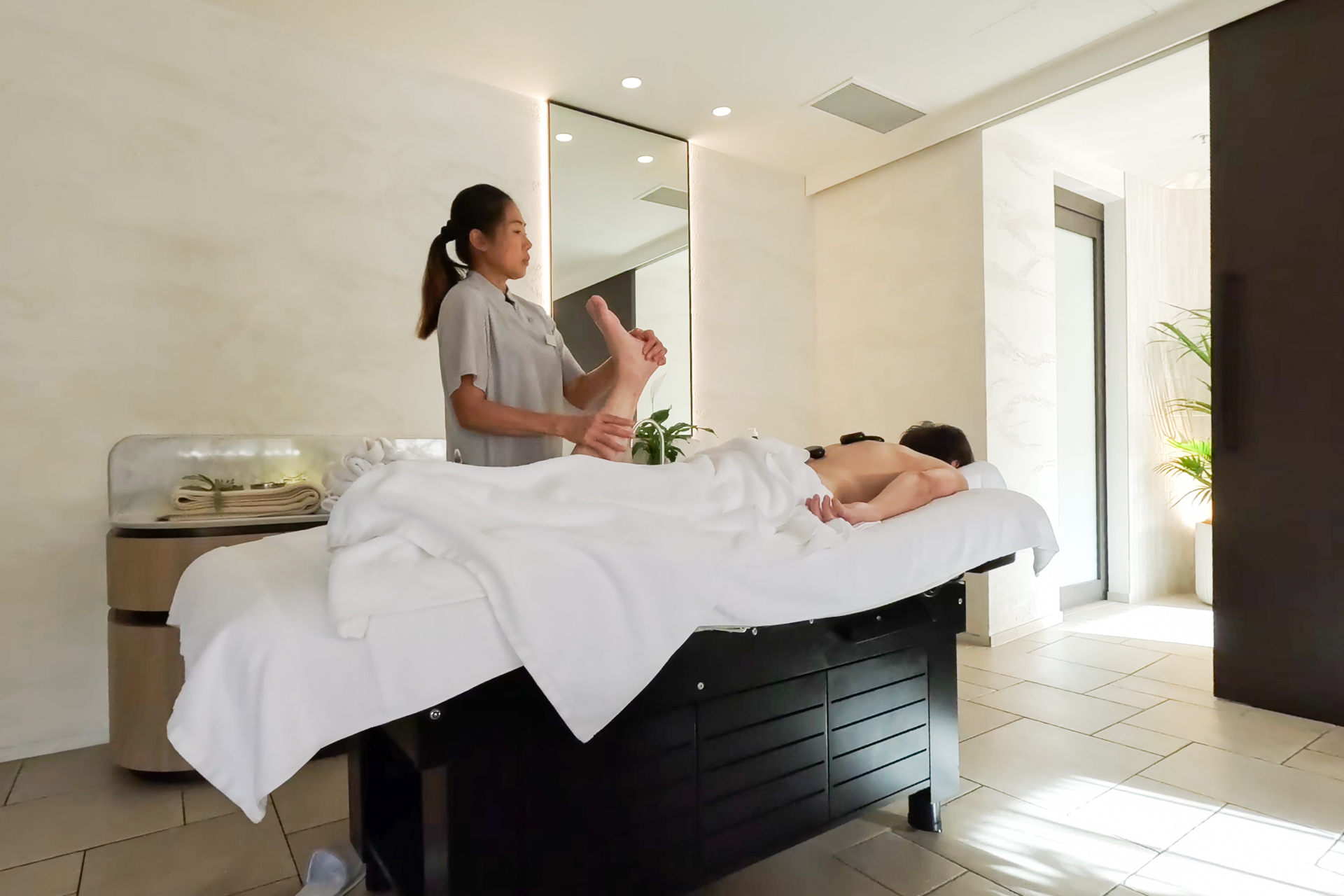 施術中の様子。背中にホットストーンが乗せられていて、ジンワリと暖かい