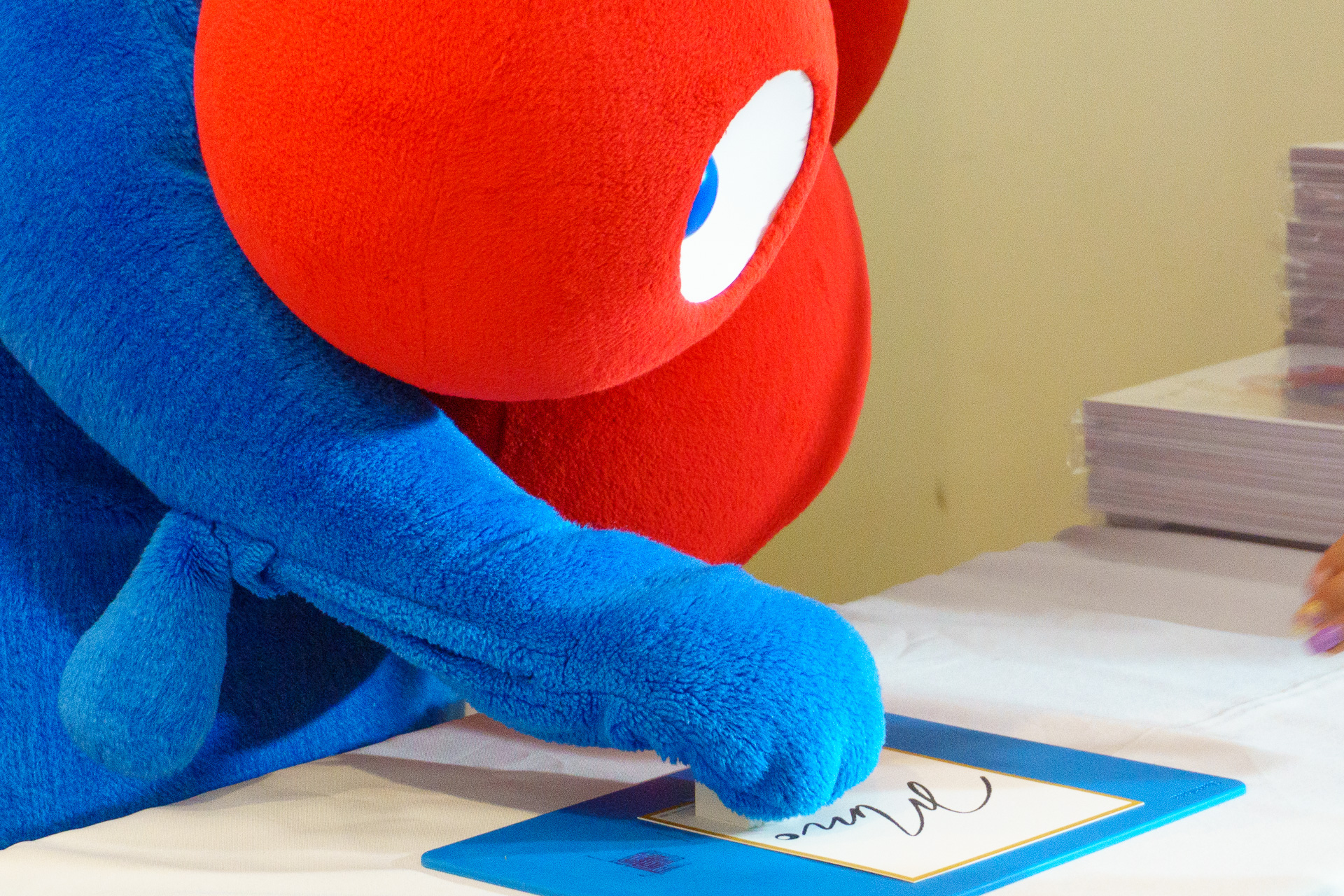 サイン色紙に落款印（スタンプ）を押すミャクミャク