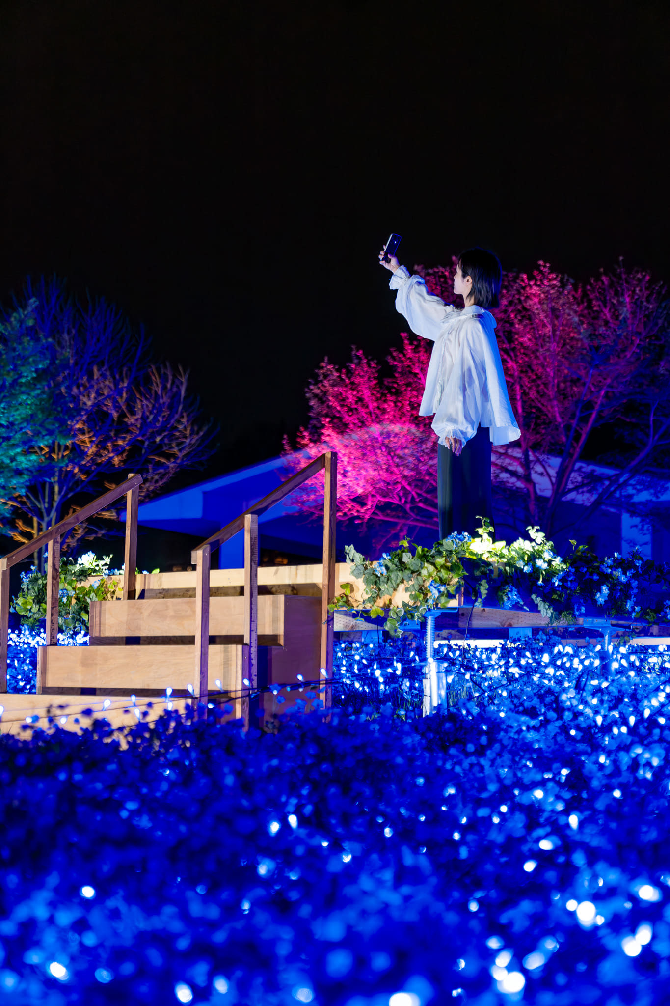 花畑の上に立って撮影できる「ネモフィラスカイステージ」。QRコードを読み込むと、スマホ上にエフェクトも出現