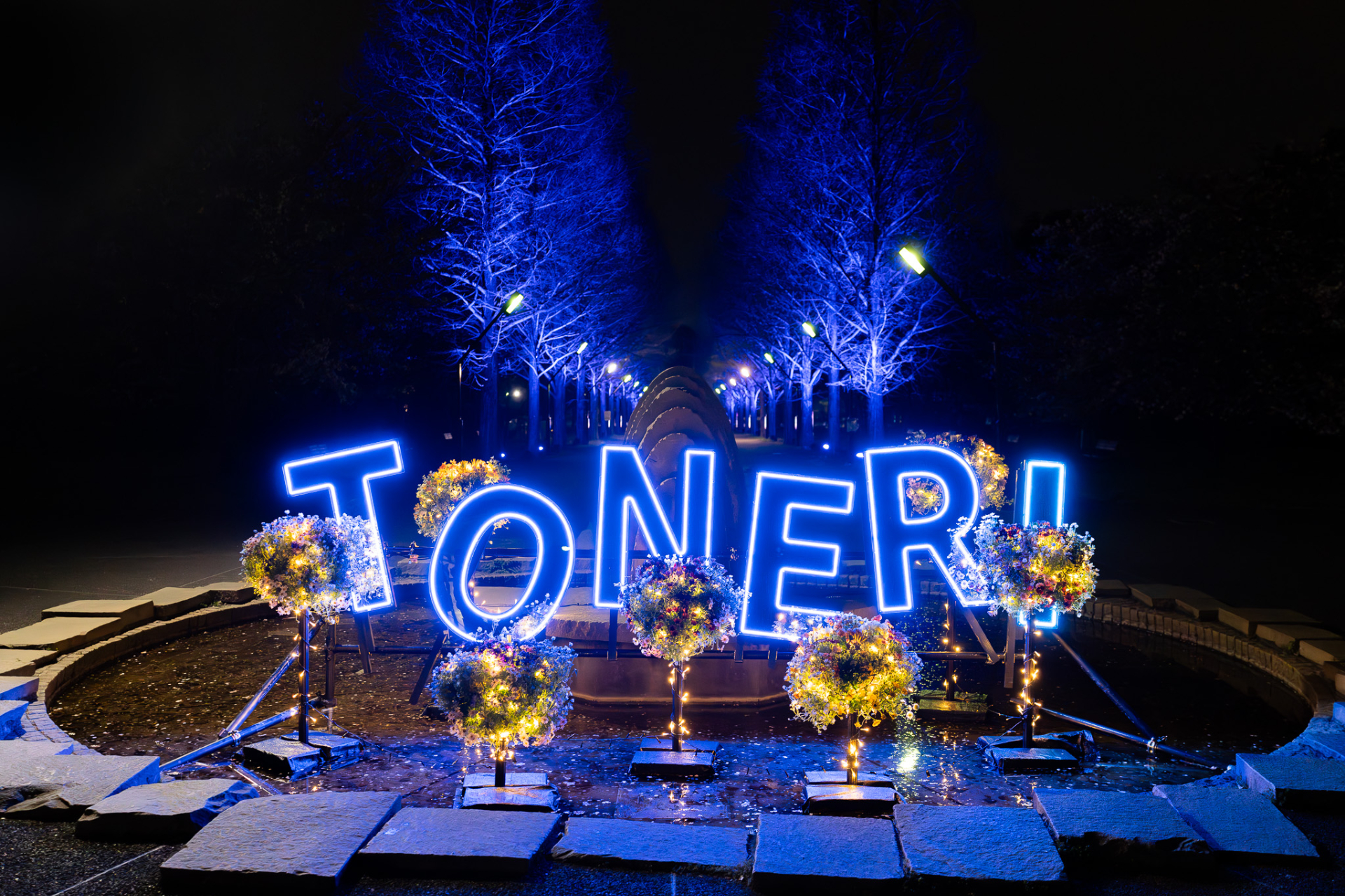 ネオンライトとミラー素材を組み合わせた「TONERI」のレターサインとメタセコイア並木