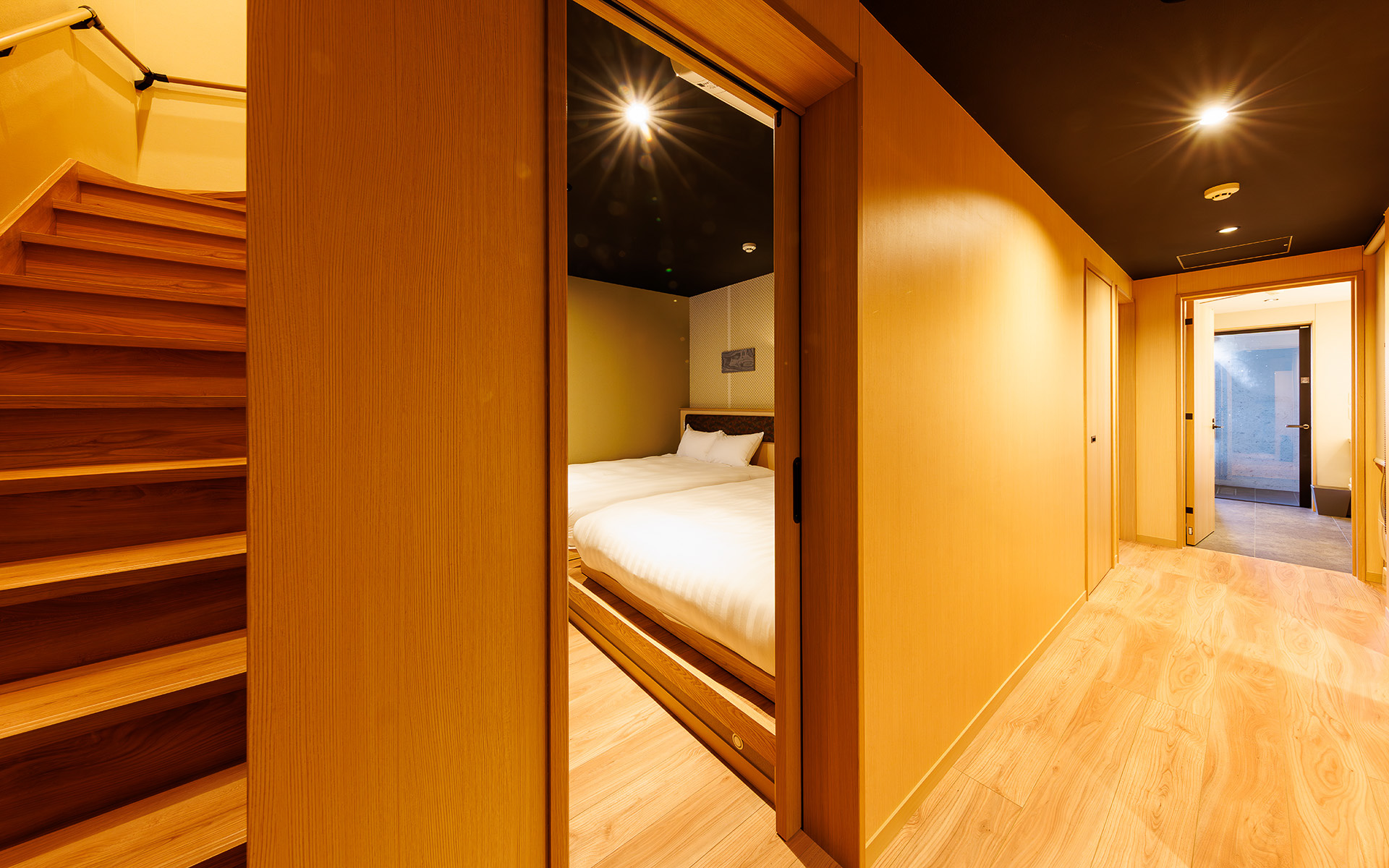 正面に洋寝室。左手が2階への階段、右手奥に温泉がある