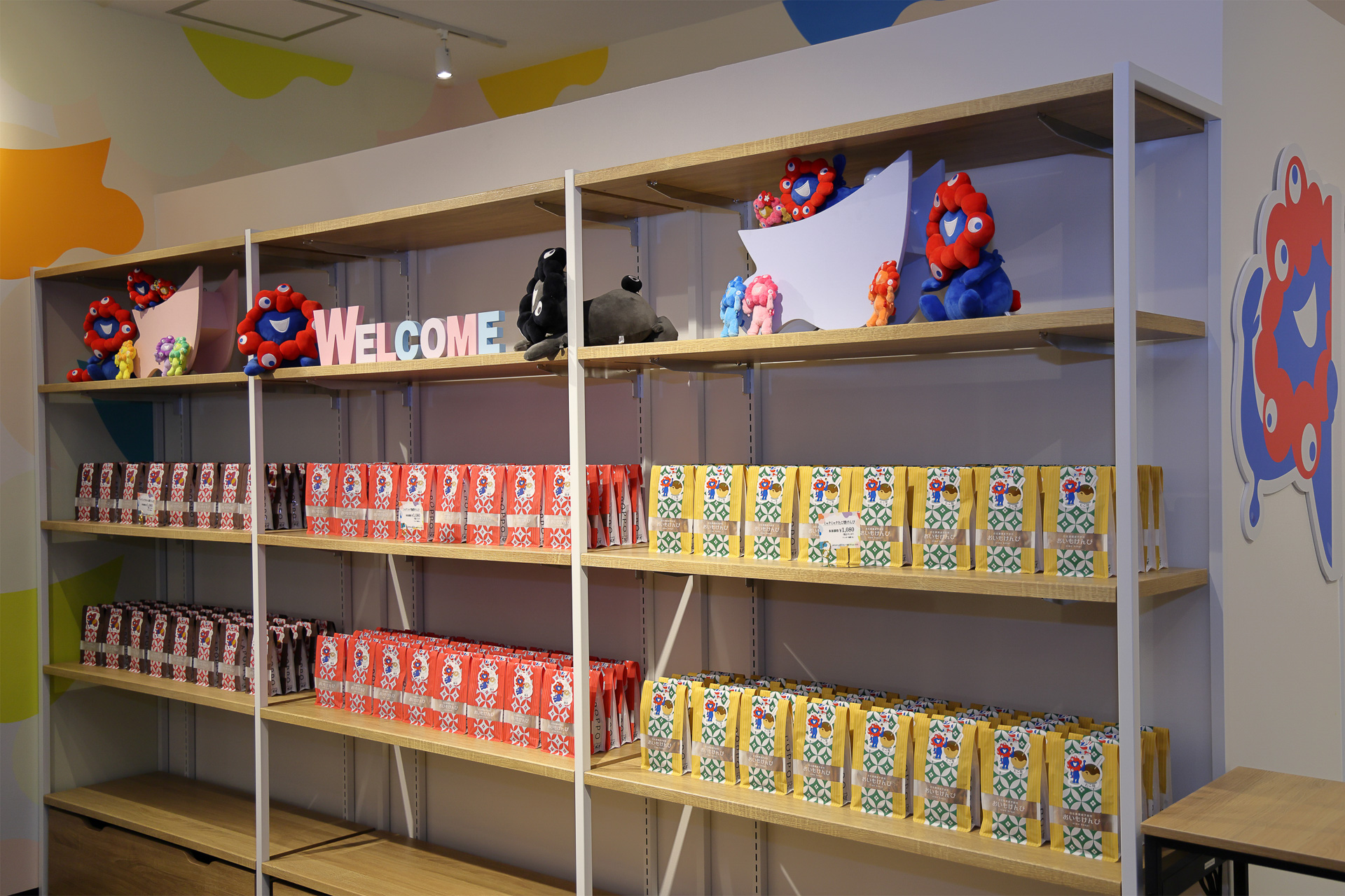 商品棚には、手前から「ミャクミャクたこ焼きけんぴ」「ミャクミャク珈琲けんぴ」「ミャクミャクおいも密けんぴ」が並ぶ。テイクアウトで楽しみたい