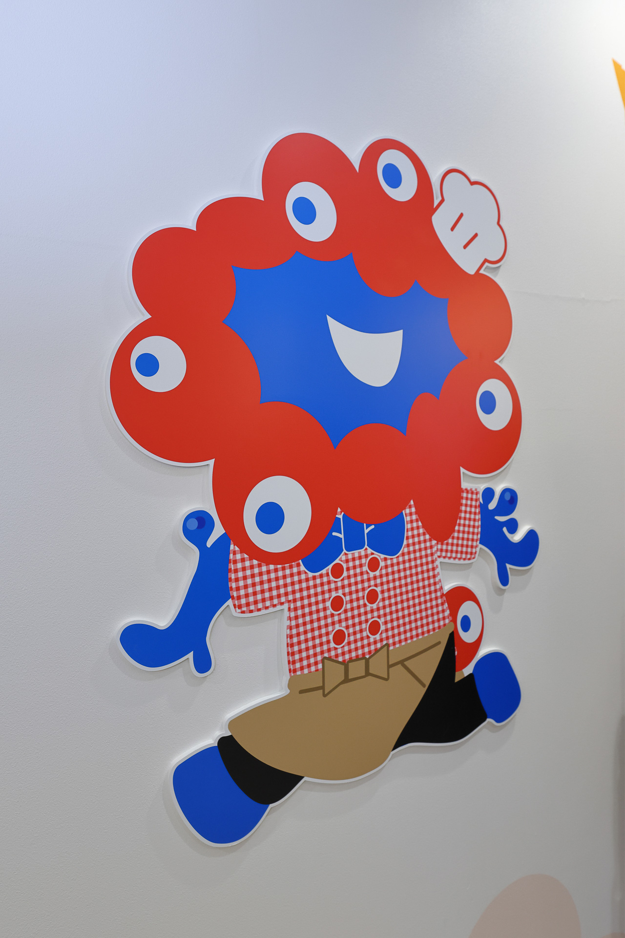 らぽっぽの制服を着て働くミャクミャク。こちらは店外の通路に描かれている