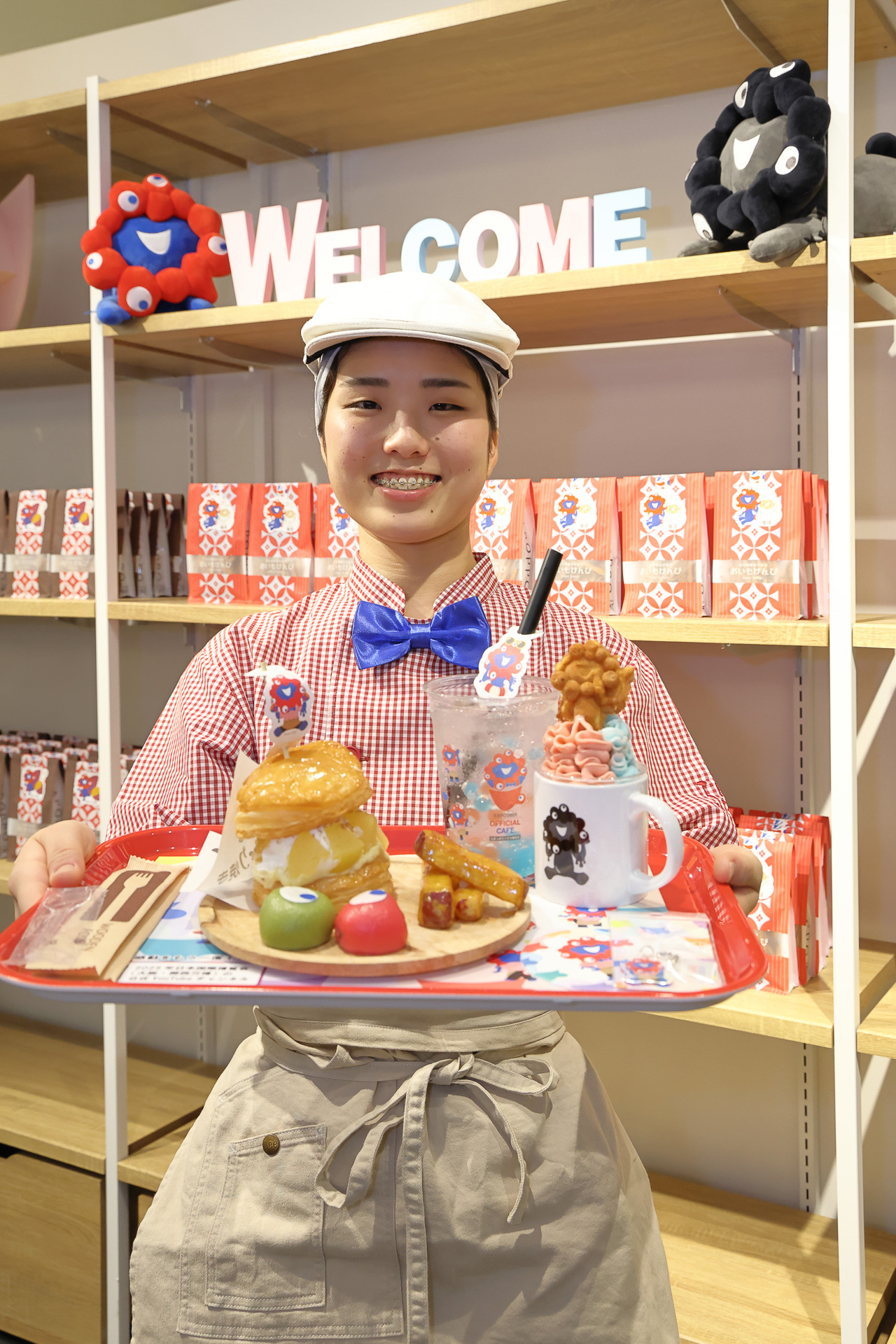 「プレートB」を持つ、らぽっぽリンクス梅田店 店長の飯山夏紀さん