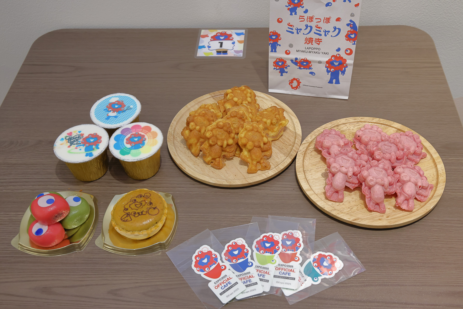 テイクアウトメニューを並べてもらった。手前のステッカーはミャクミャク焼き（人形焼）購入限定のもの