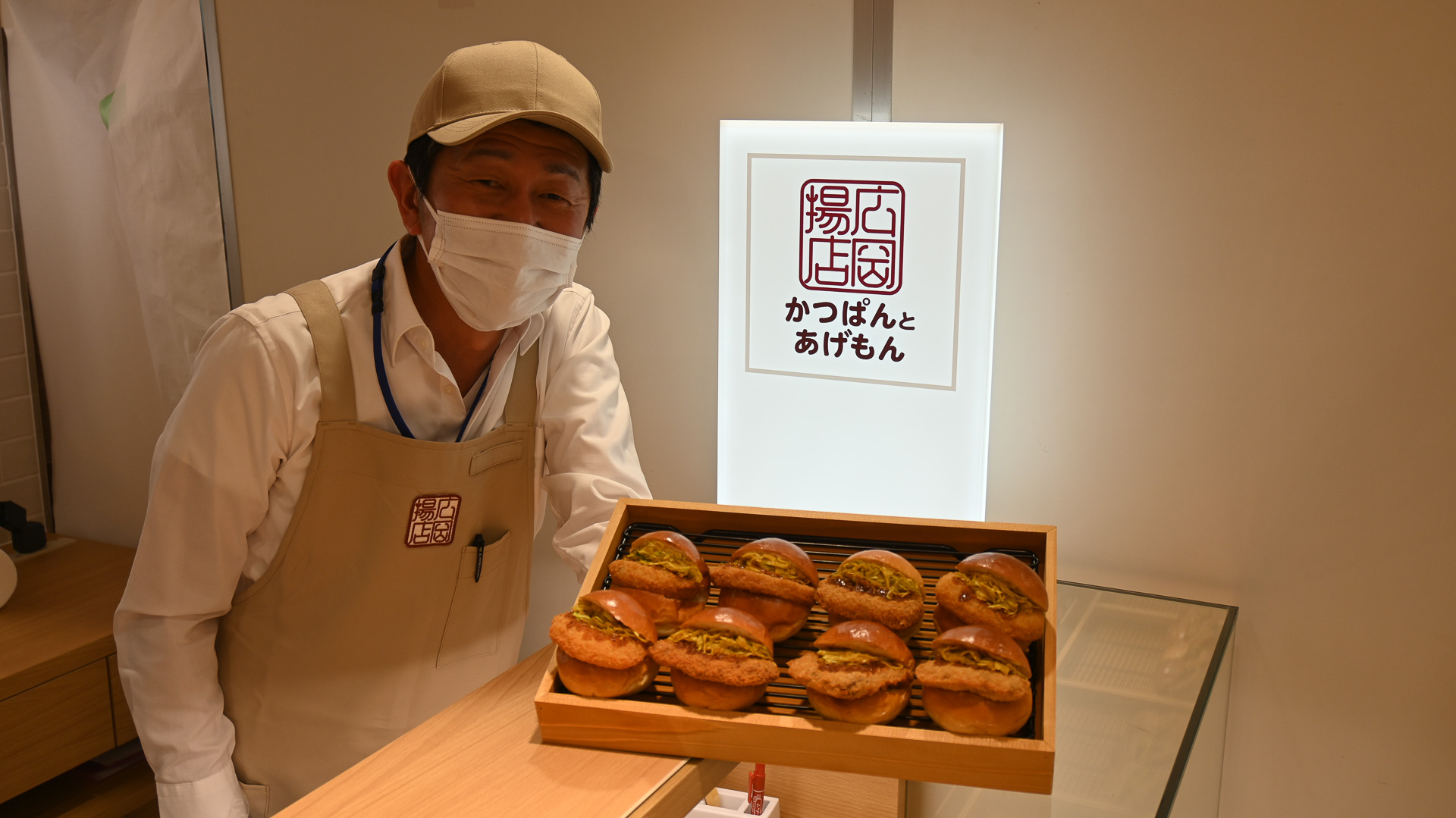 自慢のかつぱんを掲げる「広岡揚店」岩田店長