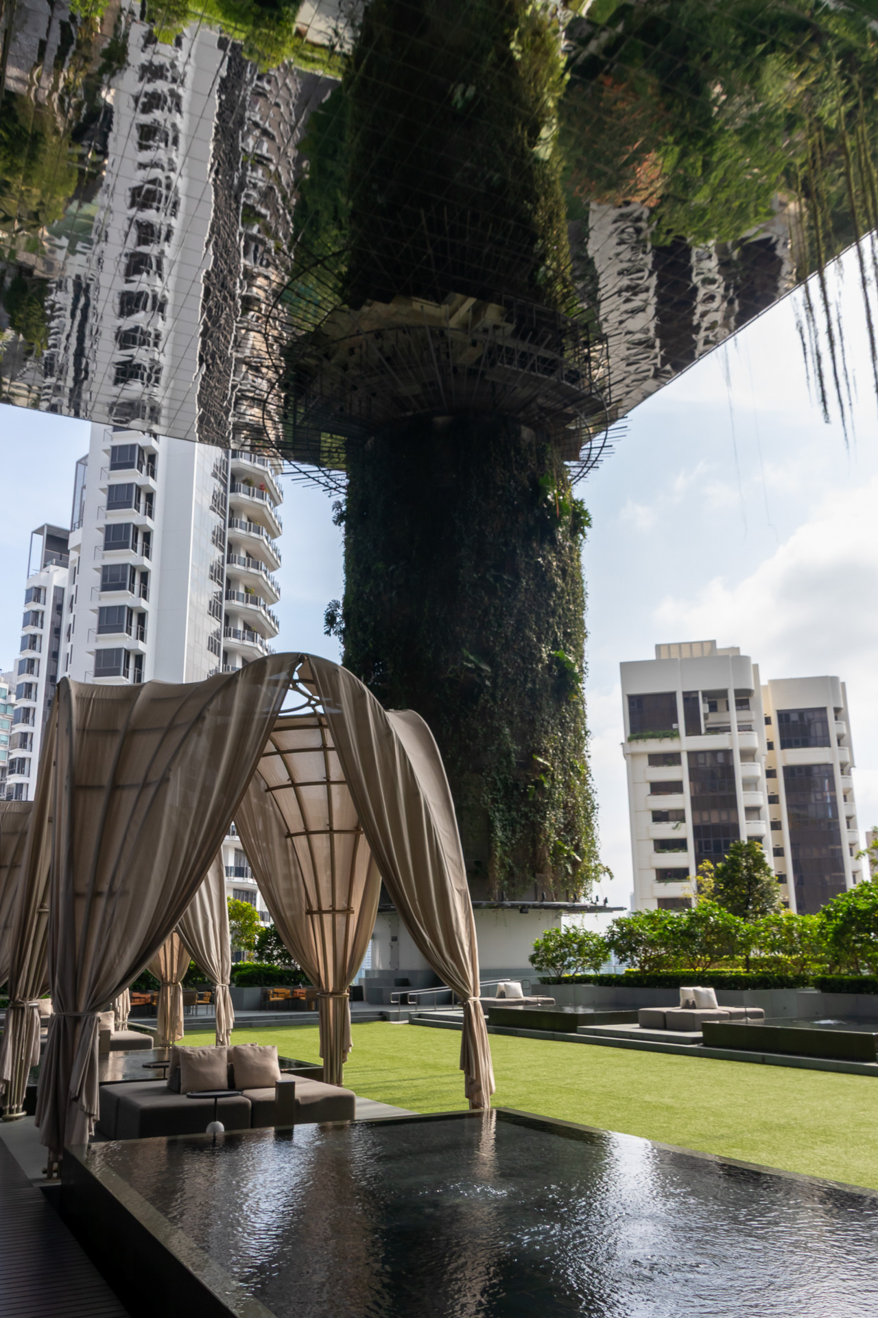 11階のテラスは庭園をイメージしたもの。植物をまとった巨大な円柱が印象的で、天井のミラーがさらなる開放感を演出している