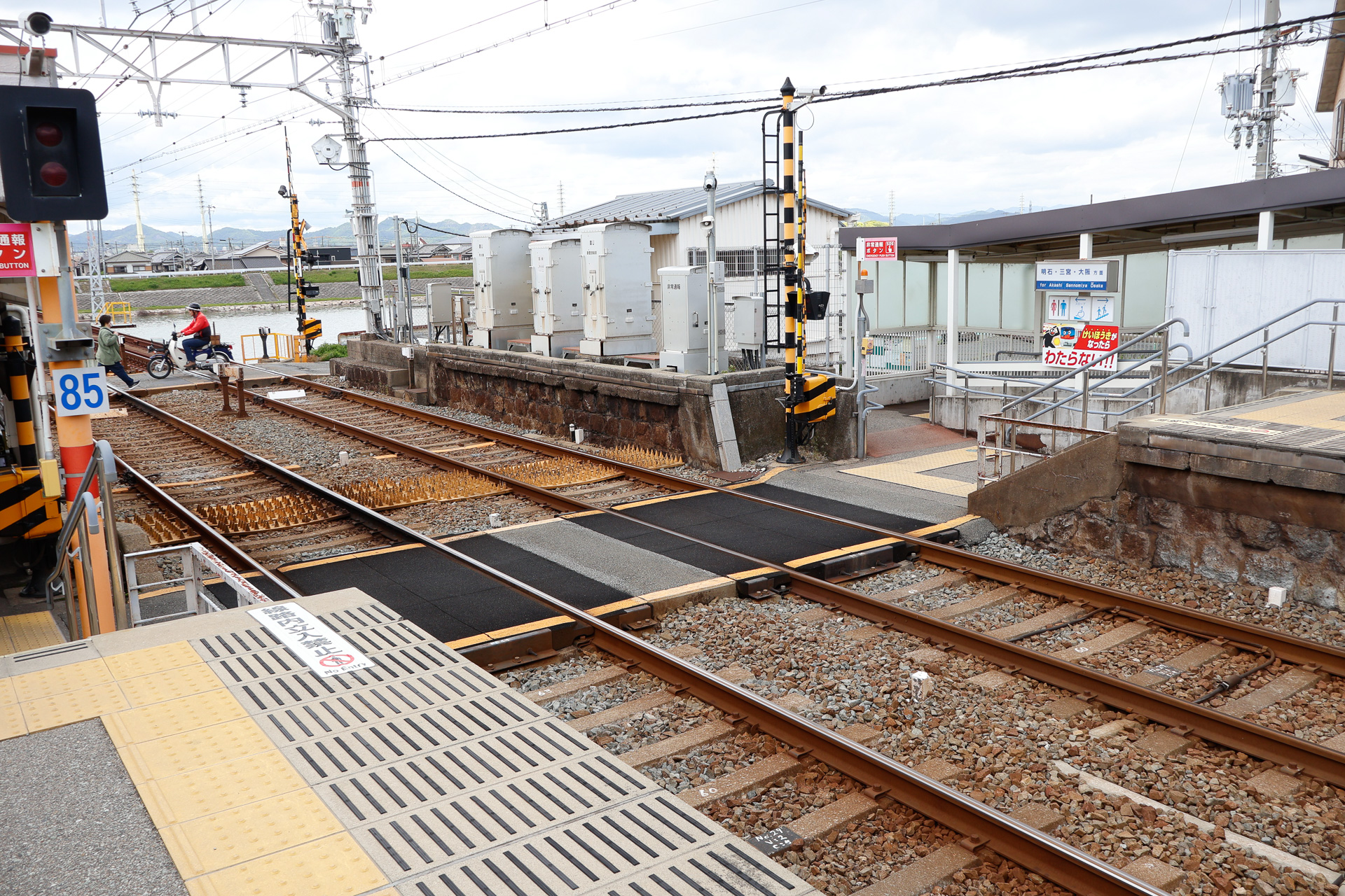 構内踏切を設けた駅の例（山陽電鉄の妻鹿駅）。上下のホームを構内踏切でつないで、電車が通るときにはその踏切を遮断する。駅舎は写真の左手、山陽姫路方面ホームにだけある