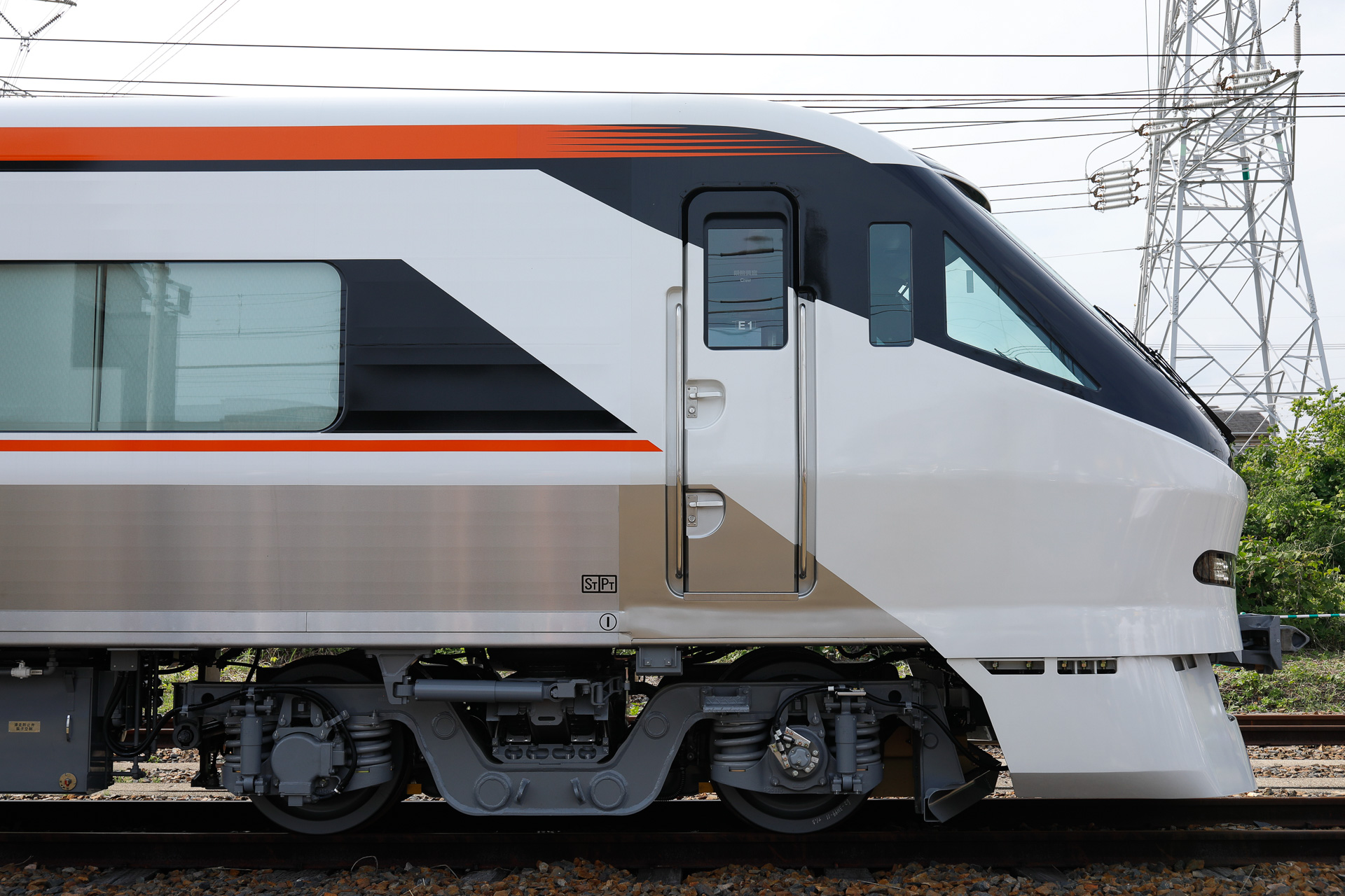 先頭部は両端とも流線型の非貫通形。1号車（グリーン車）も8号車（普通車）も運転台の直後は客室なので、最前列の席をとれば前面展望を楽しめる。白、黒、オレンジを組み合わせた側面の帯が側窓とその上部に寄せられているのは、可動柵越しに見る場面を想定したためであろうか