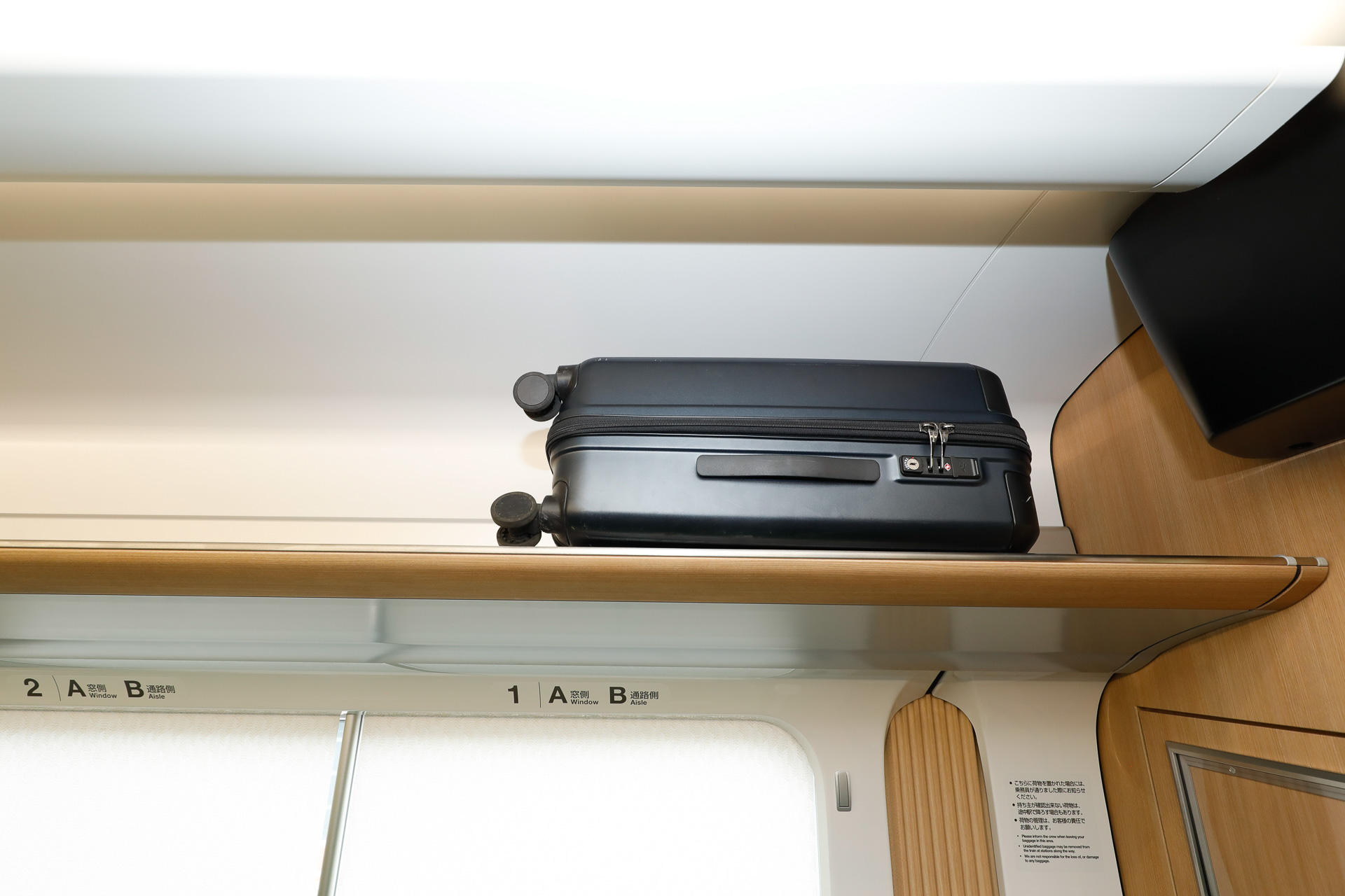 荷棚にトランクを載せた状態のサンプル。機内持ち込みサイズ（100席以上）を想定して寸法が定められた