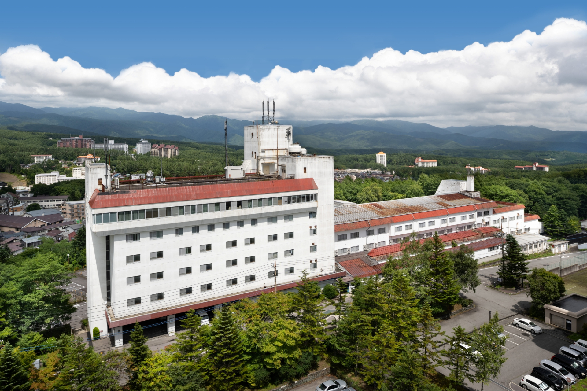 亀の井ホテル 草津リゾート。温泉街を見下ろす高台に立地し、豊かな自然のなかで万代鉱源泉100％かけ流しの湯を堪能できる