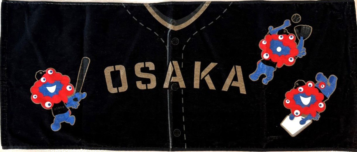 後日販売開始予定のフェイスタオル。ブラックを基調に、ミャクミャクと「OSAKA」の文字を組み合わせた