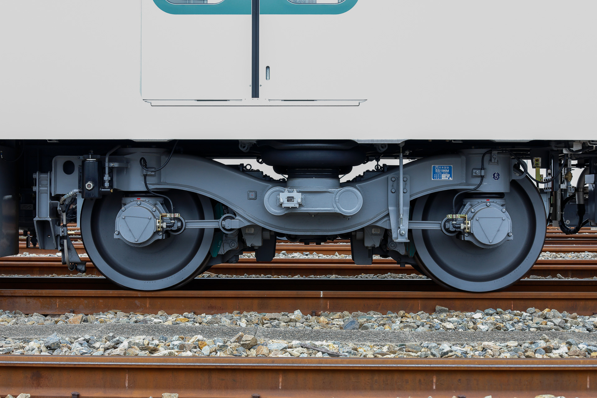 90000系の電動台車。形式はSS196M（TRS-25M）。10両のうち6両はモーターがない付随車で、そちらの台車形式はSS196T（TRS-25T）。なお、一部の電動台車には空転防止のためのセラミック噴射装置が取り付けられている（写真の左側軸）
