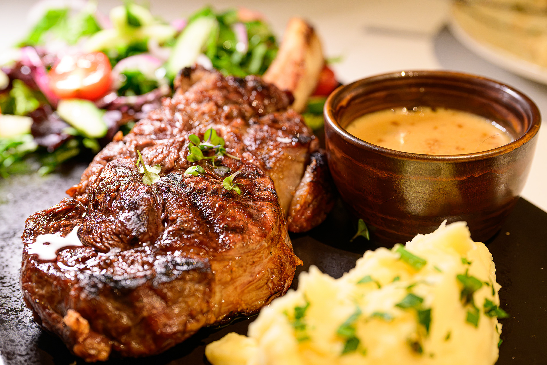 「Tablelands Rib Eye with Bone 400g」テーブルランド産の骨付きリブアイに、マッシュポテトとソースを添える。見た目のゴツさとは裏腹に柔らかくジューシーな肉質