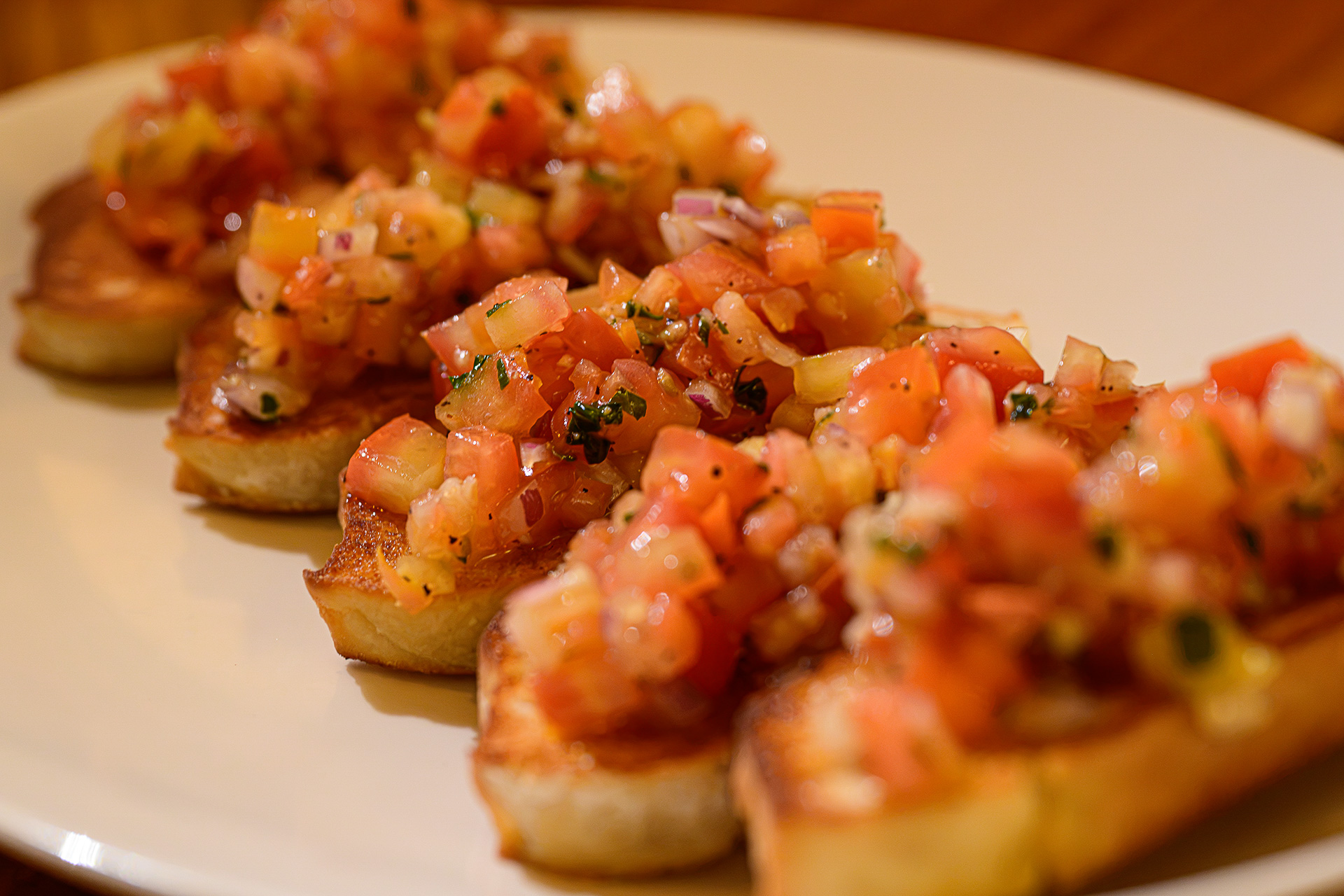 トーストしたチャバタにトマト、玉ねぎ、バジル、ガーリック、オリーブオイルを乗せた前菜のBruschetta