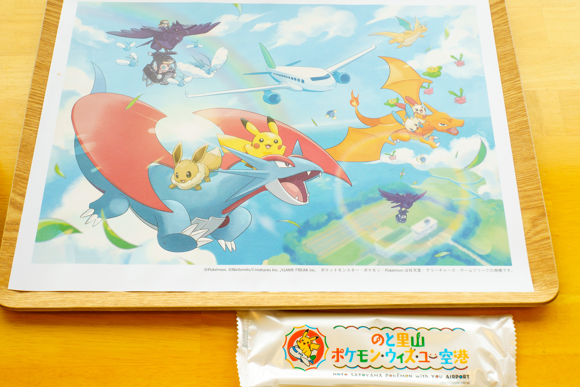 空港オリジナルアート「きぼうのそら」が描かれた特製ランチョンマットと空港ロゴデザインのおしぼり