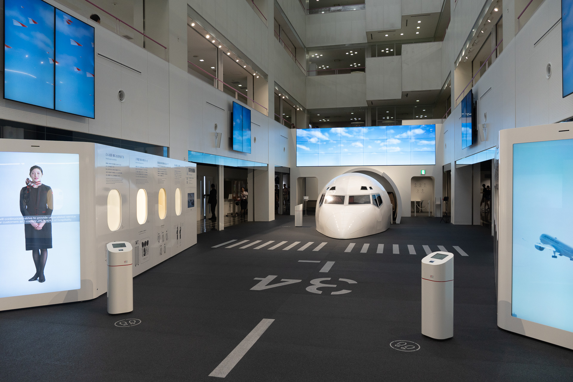 JAL SKY MUSEUMの象徴的なスペース「スカイランウェイ」。左右の大型ディスプレイやタッチパネルを通じて空の仕事への理解を深められる
