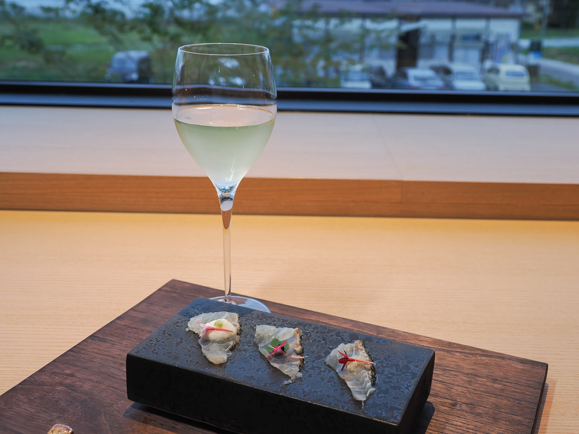 造りの「鰹銀皮造り」、このあと「石巻産鯛昆布締め」「三陸産鱸藁焼き」が続く。窓の夕景がキレイだ