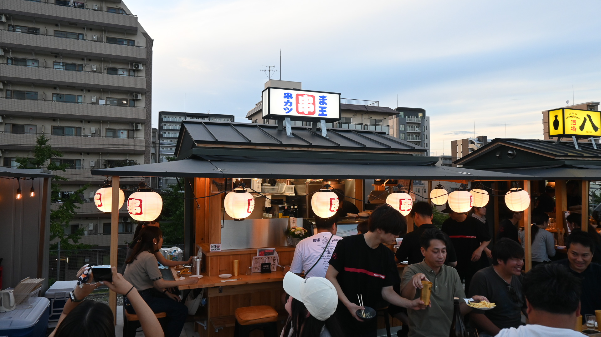 店舗はコンテナをベースに、折り畳み式の屋根を広げるスタイル。写真は串カツ「ま王」