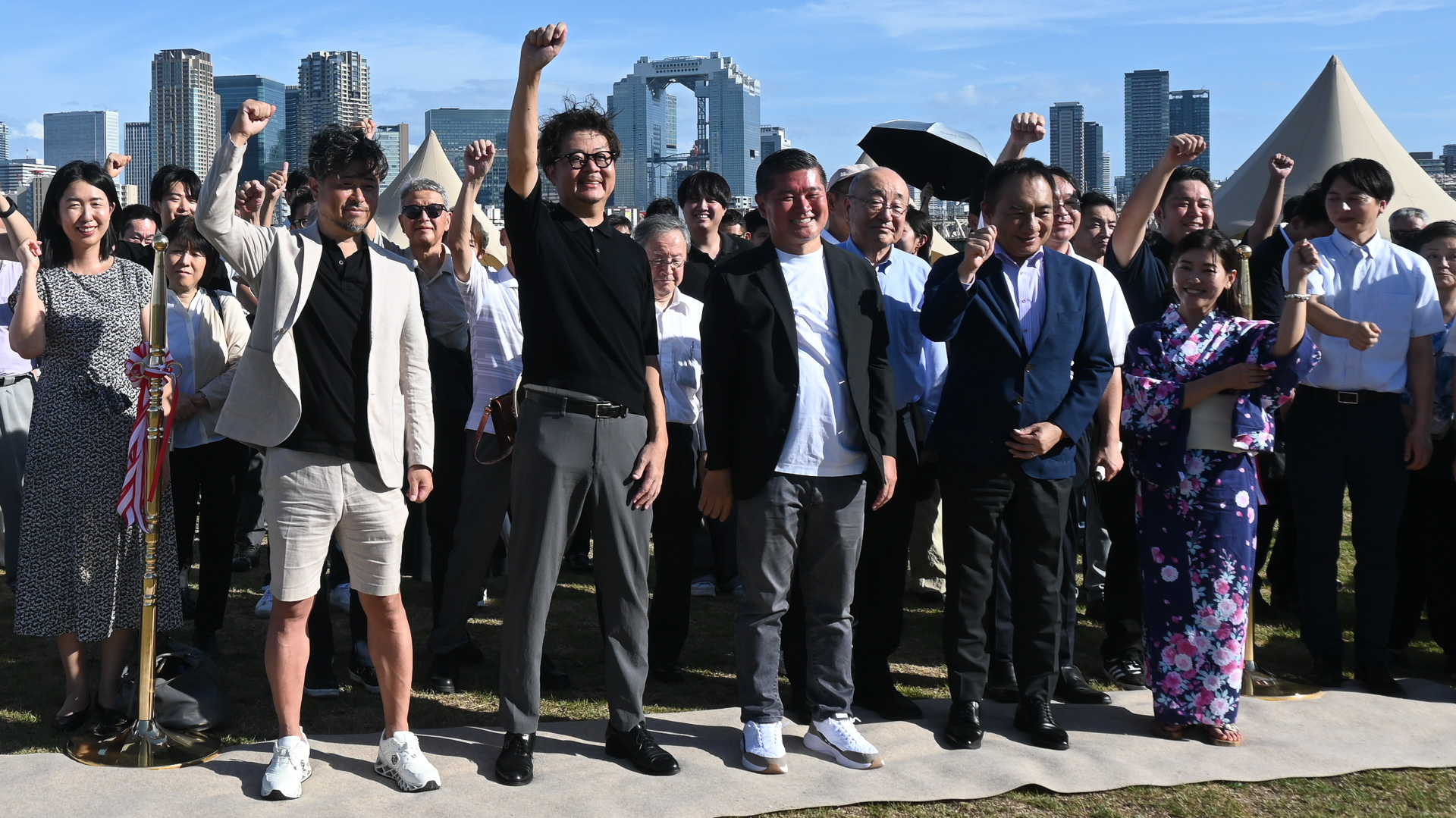 左から、株式会社Wonder Group 代表取締役 堀感治氏、株式会社類設計室 執行役員 野﨑章氏、株式会社RETOWN 代表取締役 松本篤氏、淀川区長 古川吉隆氏、大阪市会議員 佐竹りほ氏。後ろに並ぶのは、十三の住民団体、商店街などの関係者の方々