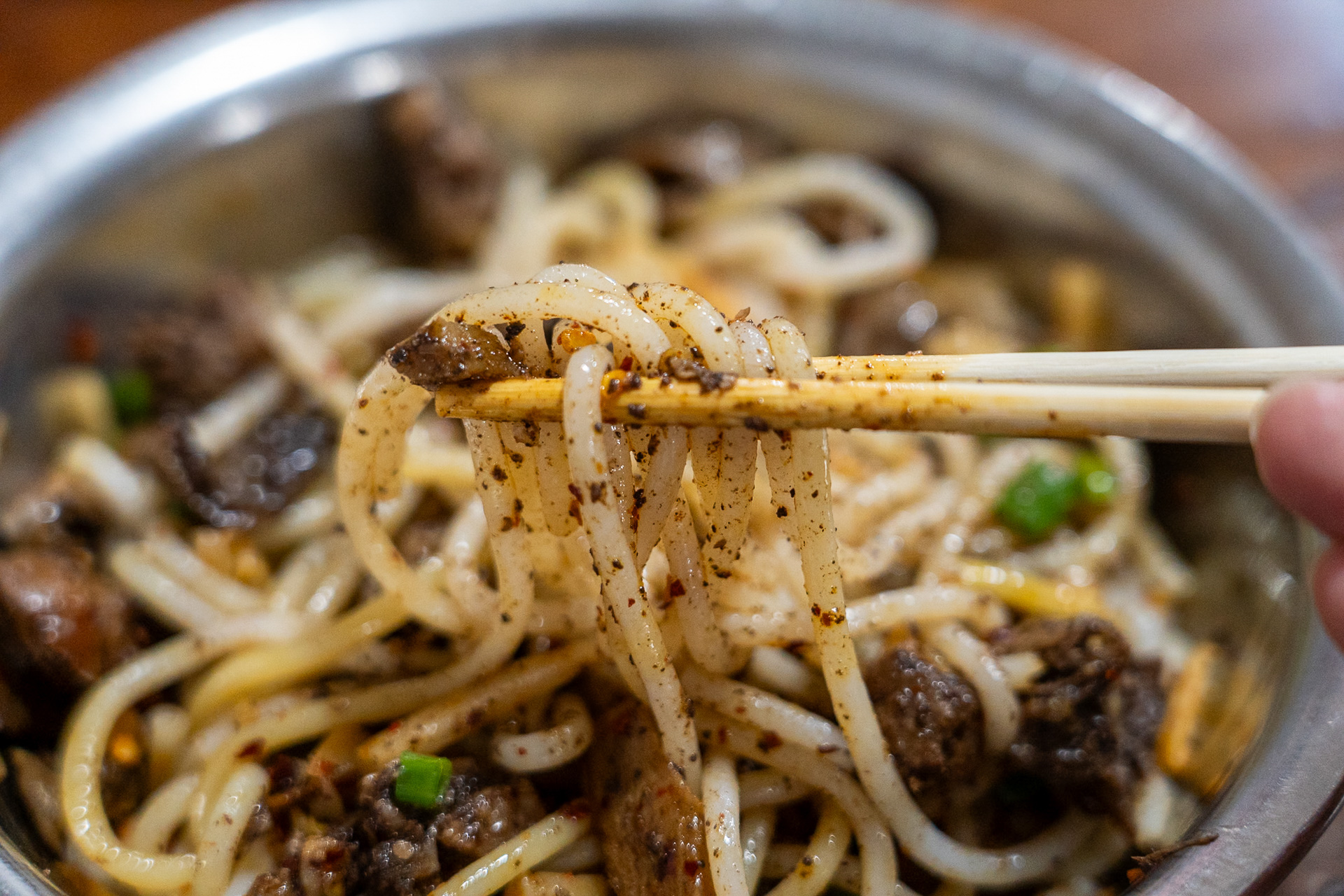 もっちりツルツルのスパゲティのような麺。丼の底に、漢方と牛肉の旨味が詰まった濃厚タレが仕込まれているのでよくかき混ぜます