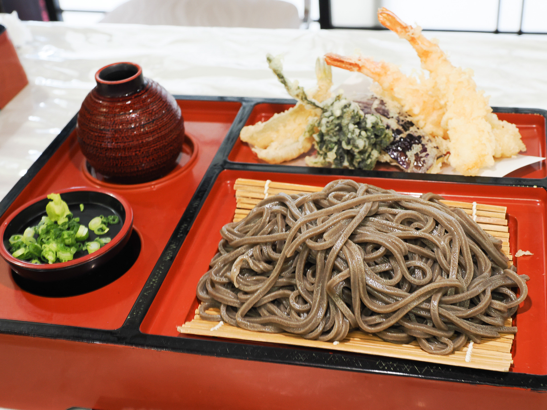 東松島名物グルメ「東松島のりうどん」。見た目はそばのようだが海苔風味が濃いうどん。天ぷらも付く
