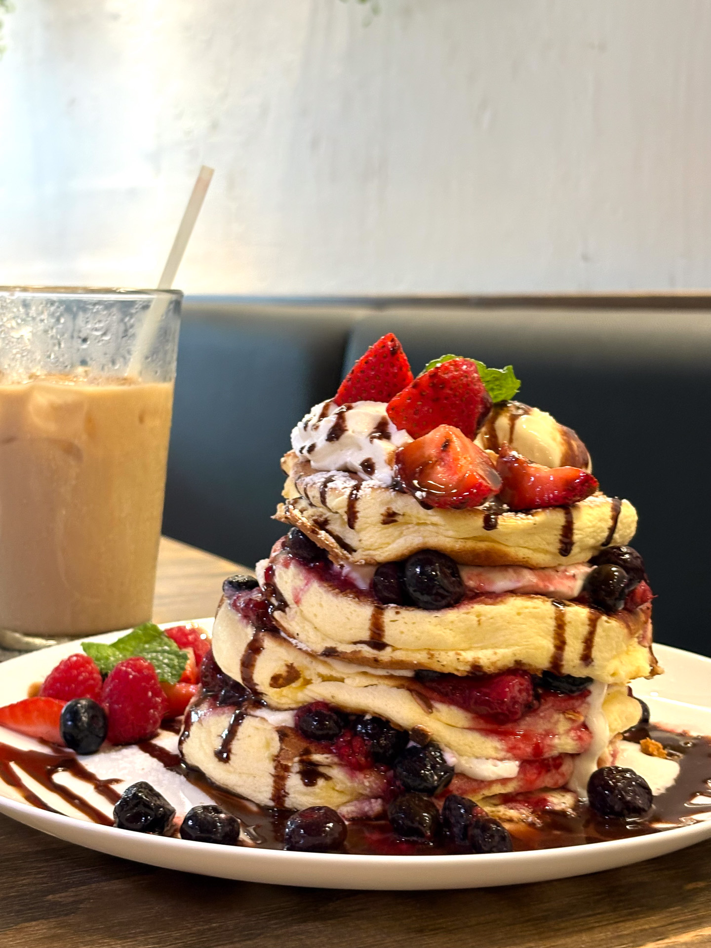 イチゴスフレパンケーキ（4枚重ね22ドル）。ホイップクリームとクッキークリームバニラアイスクリーム、イチゴやラズベリーに、チョコレートソースがかかっている