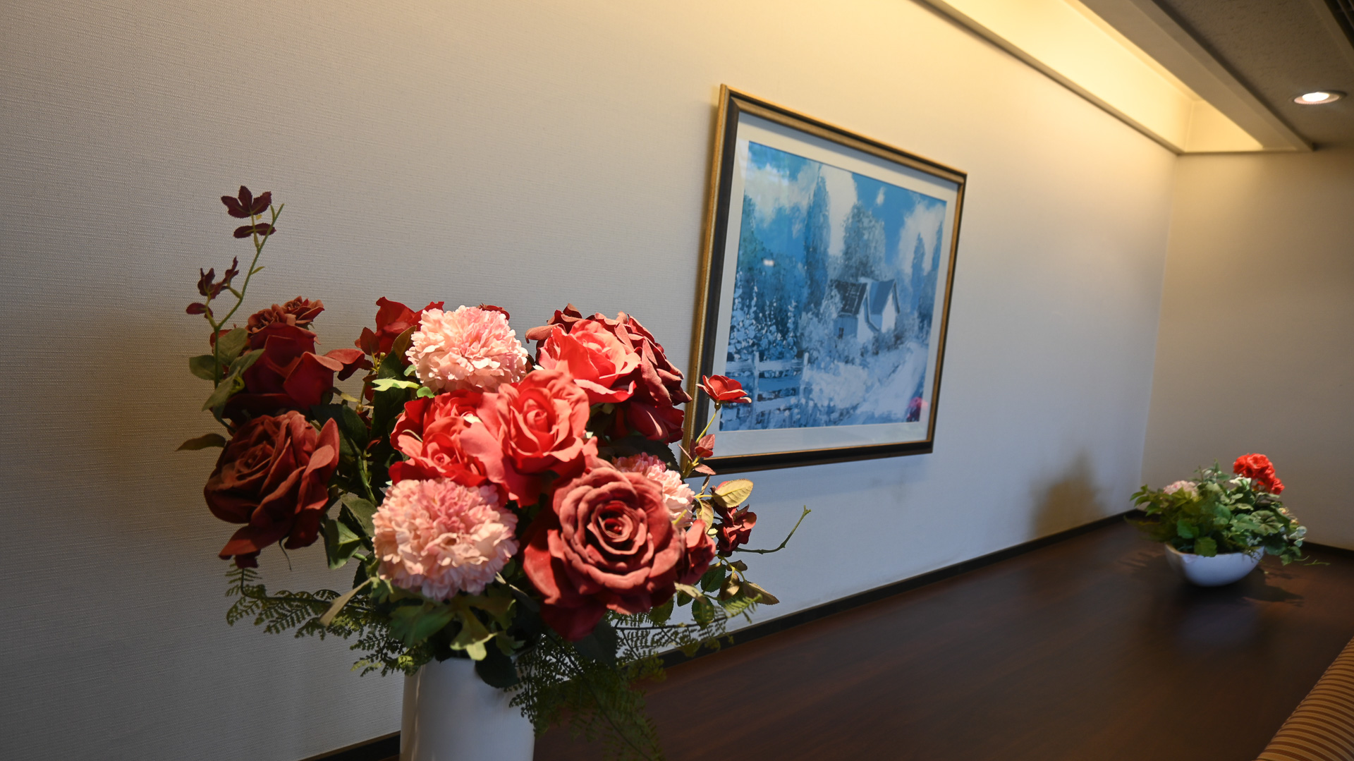 座席奥に飾られた、薔薇の花束とアート