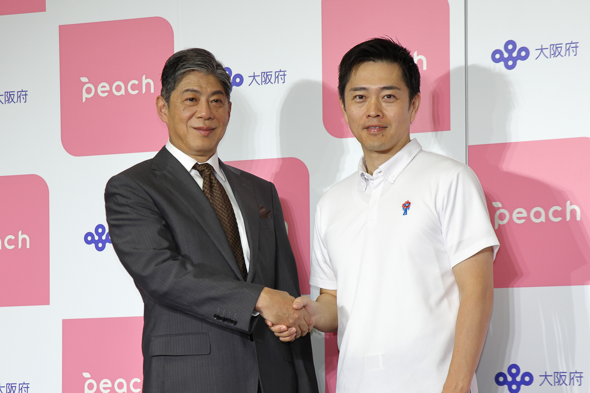 握手を交わすピーチの大橋CEOと吉村洋文大阪府知事