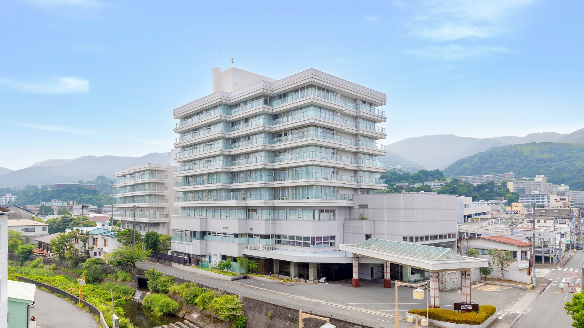 伊東大川沿いに佇む伊東ホテルニュー岡部。JR伊東駅からは徒歩15分で、無料シャトルバスあり